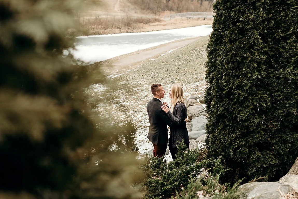 Engaged couple slow dancing between some trees