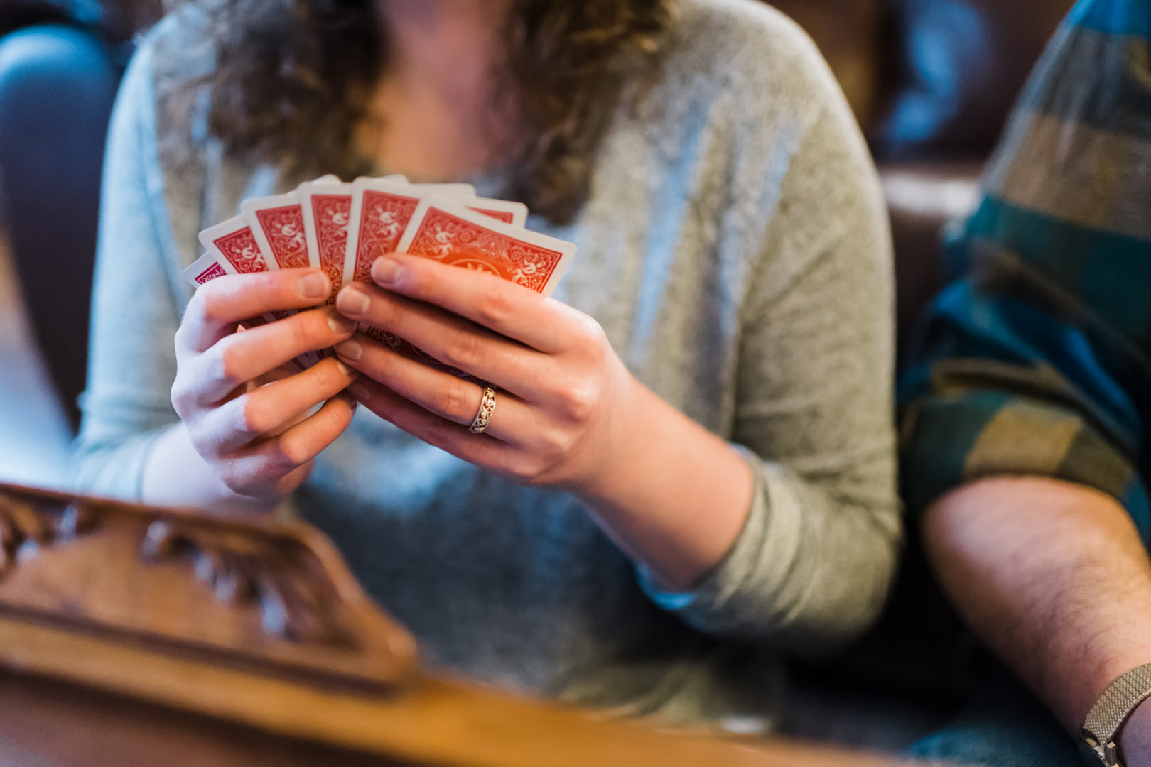 Woman holding deck of cards and showing engagement ring