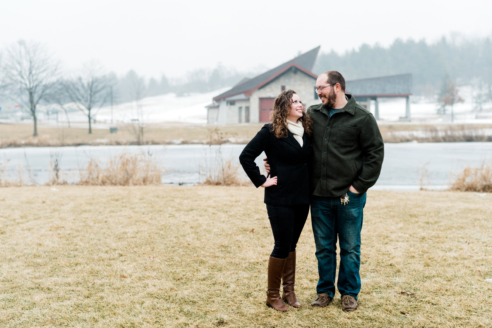 Engaged couple looking at each other outside on a misty day