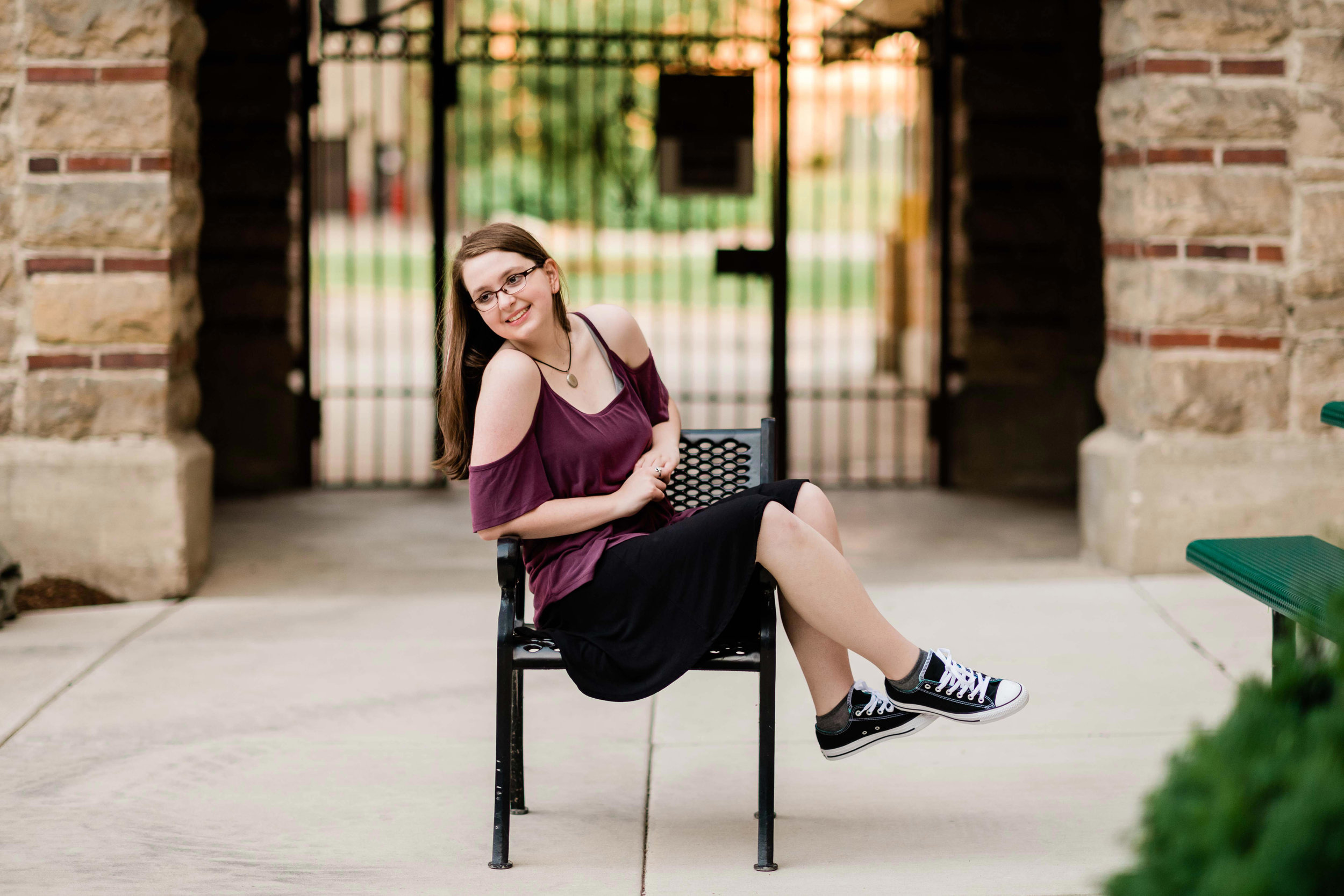 High school senior sitting on a chair outside