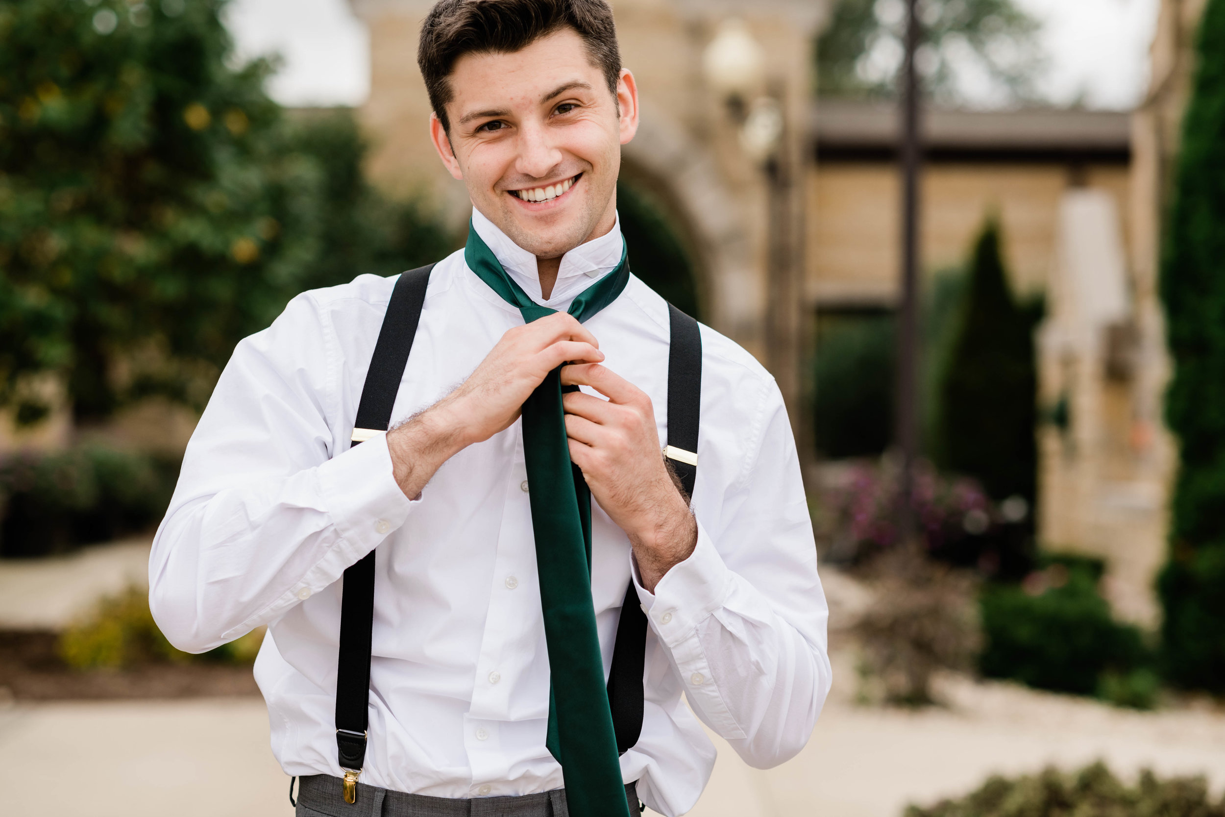 Groom putting on his tie