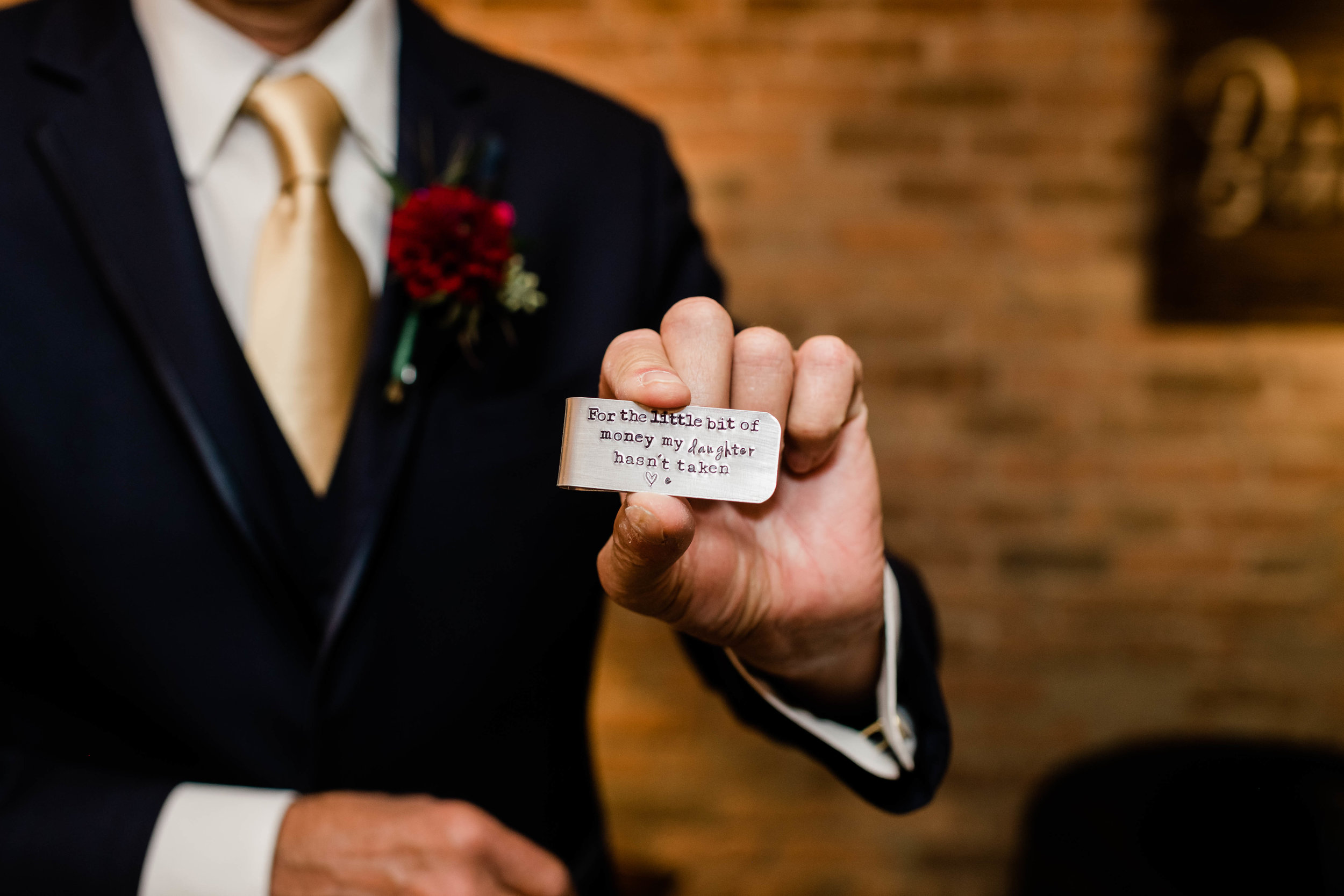 Father of the bride holding a money clip with the inscription "for the little bit my daughter hasn't taken"