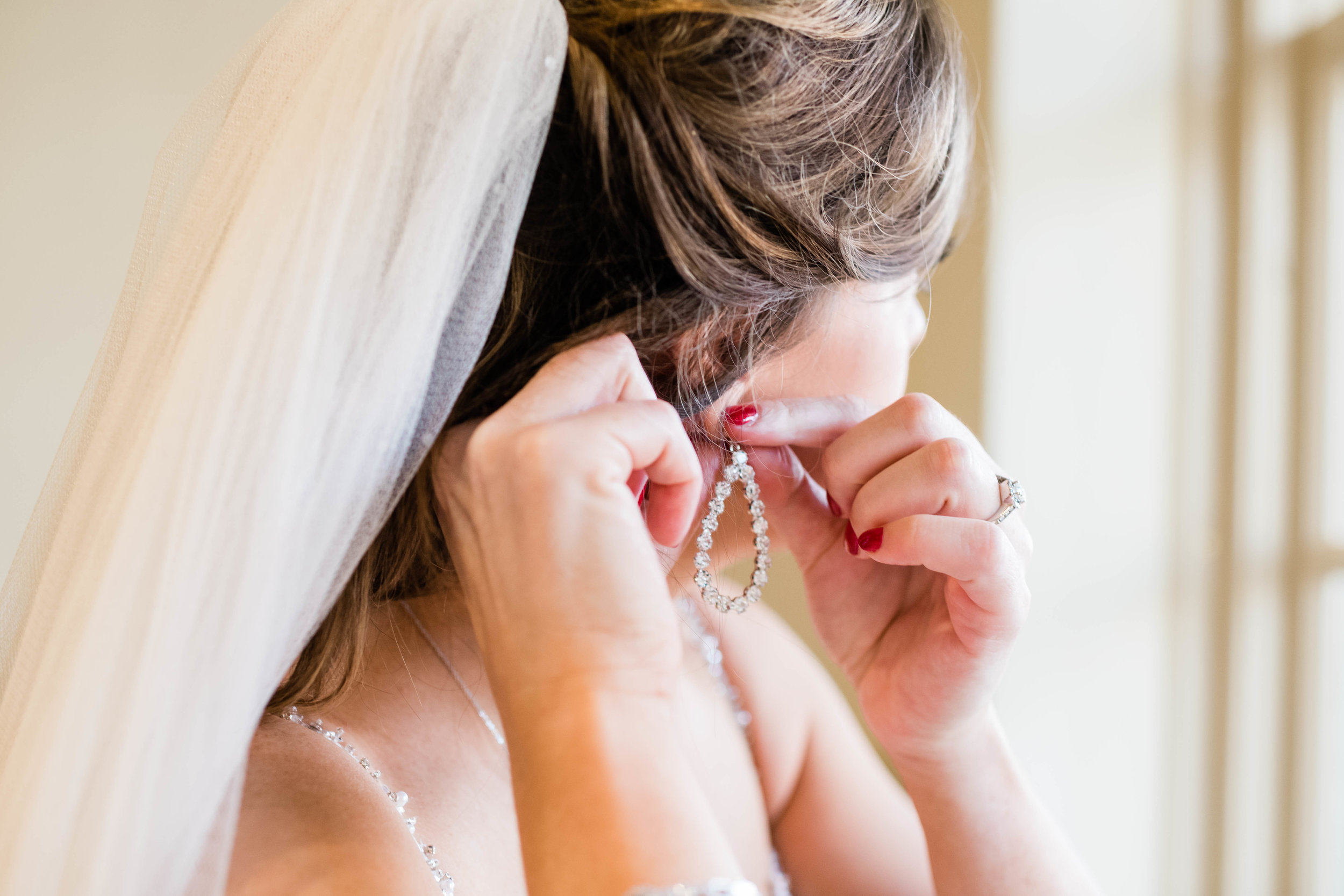 Bride putting on an earring