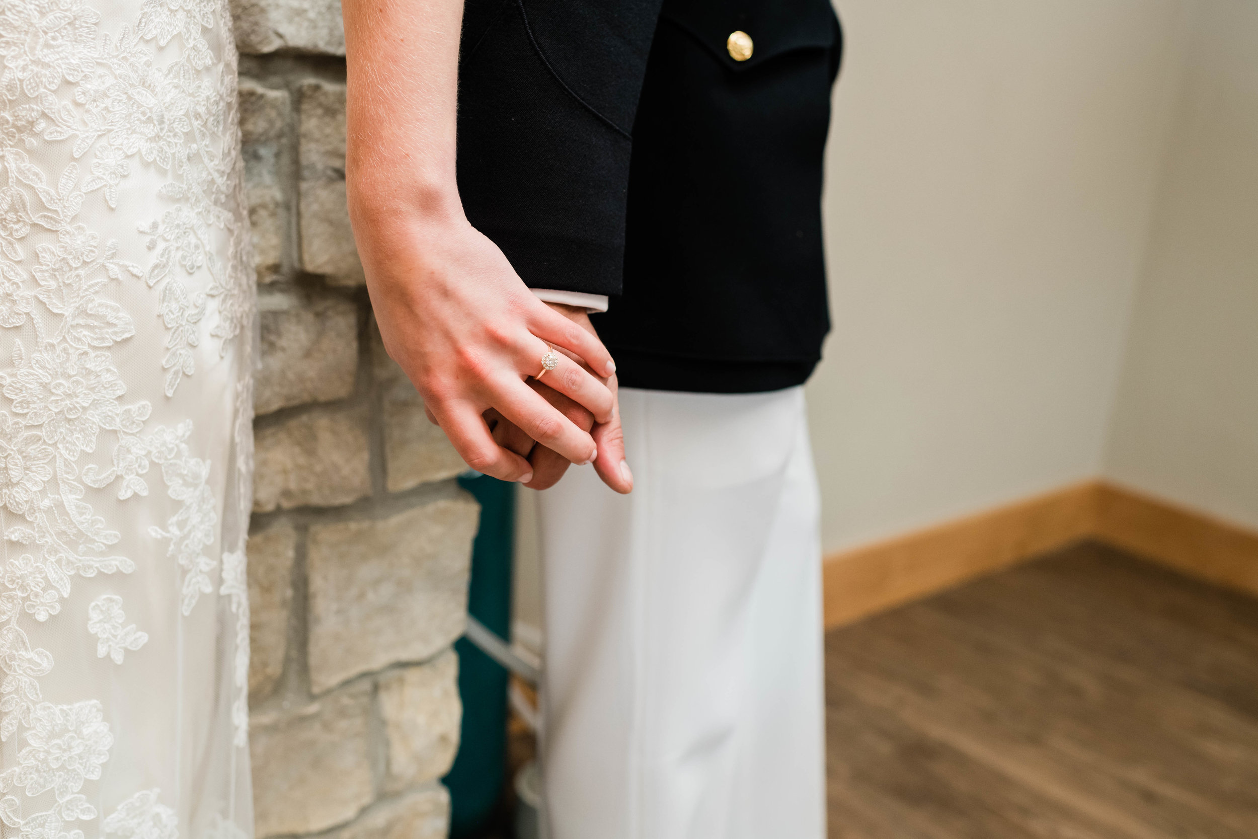 Bride and groom hold hands without seeing each other