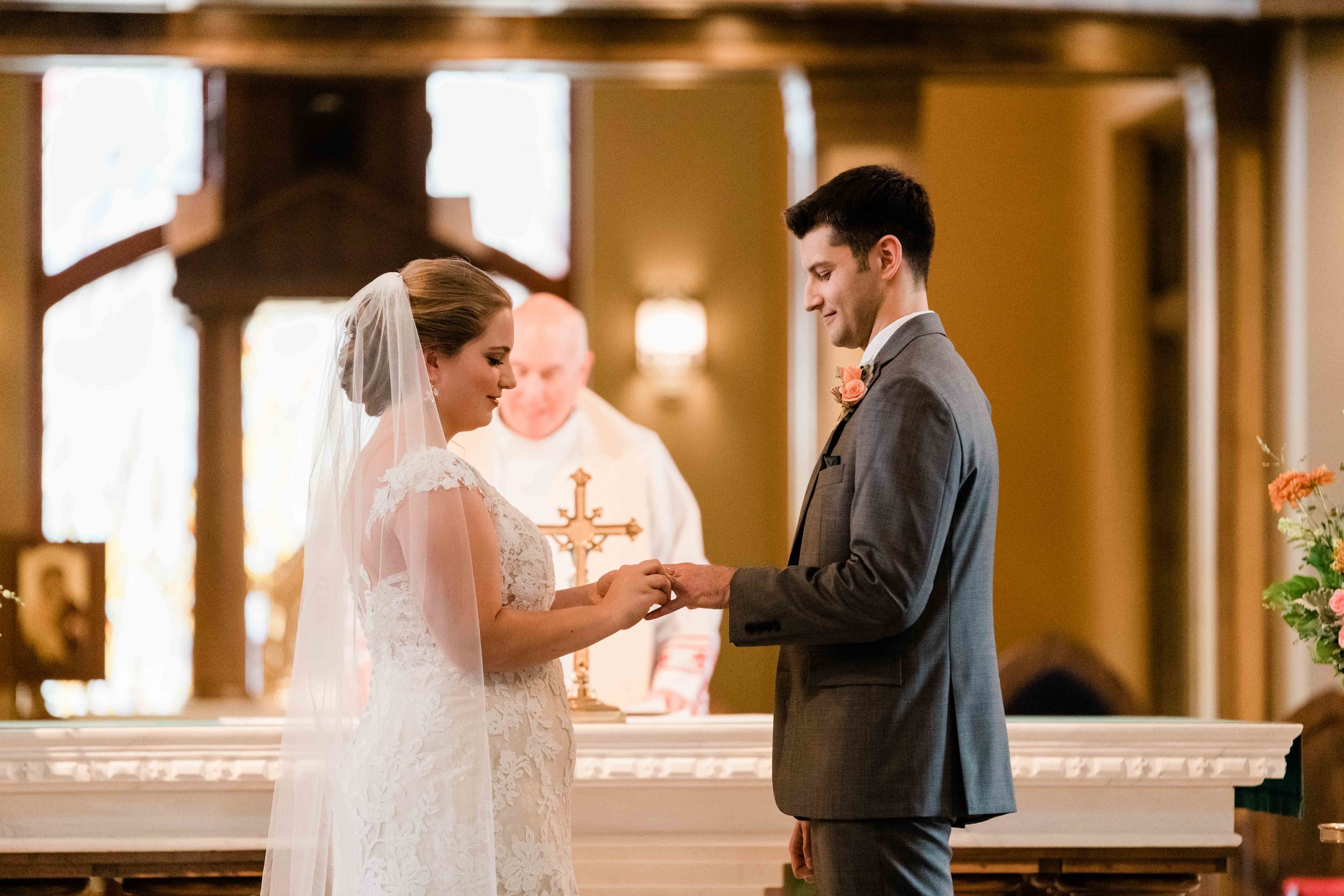 Bride and groom exchange rings during the wedding ceremony