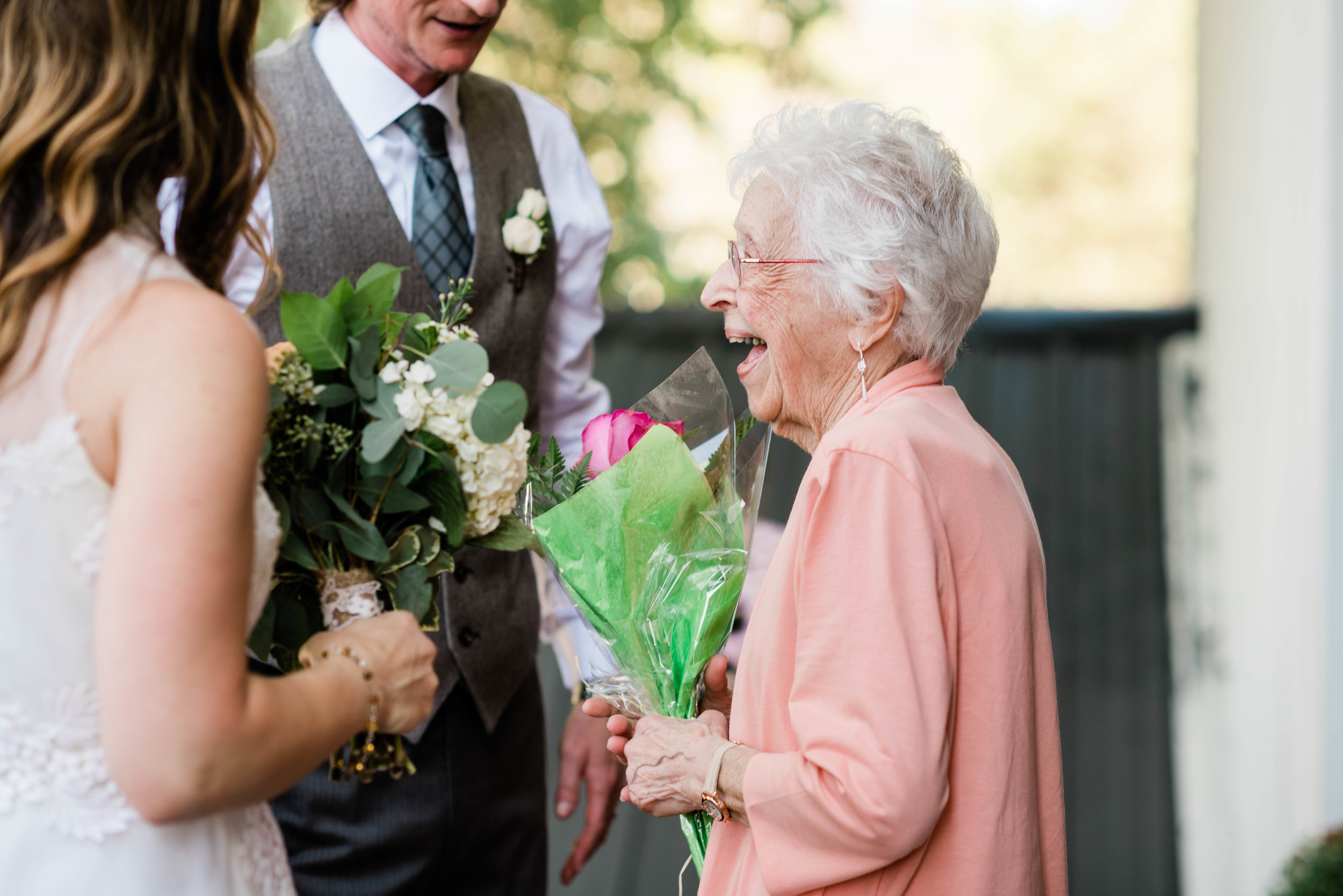 Grandma laughing with bride and groom