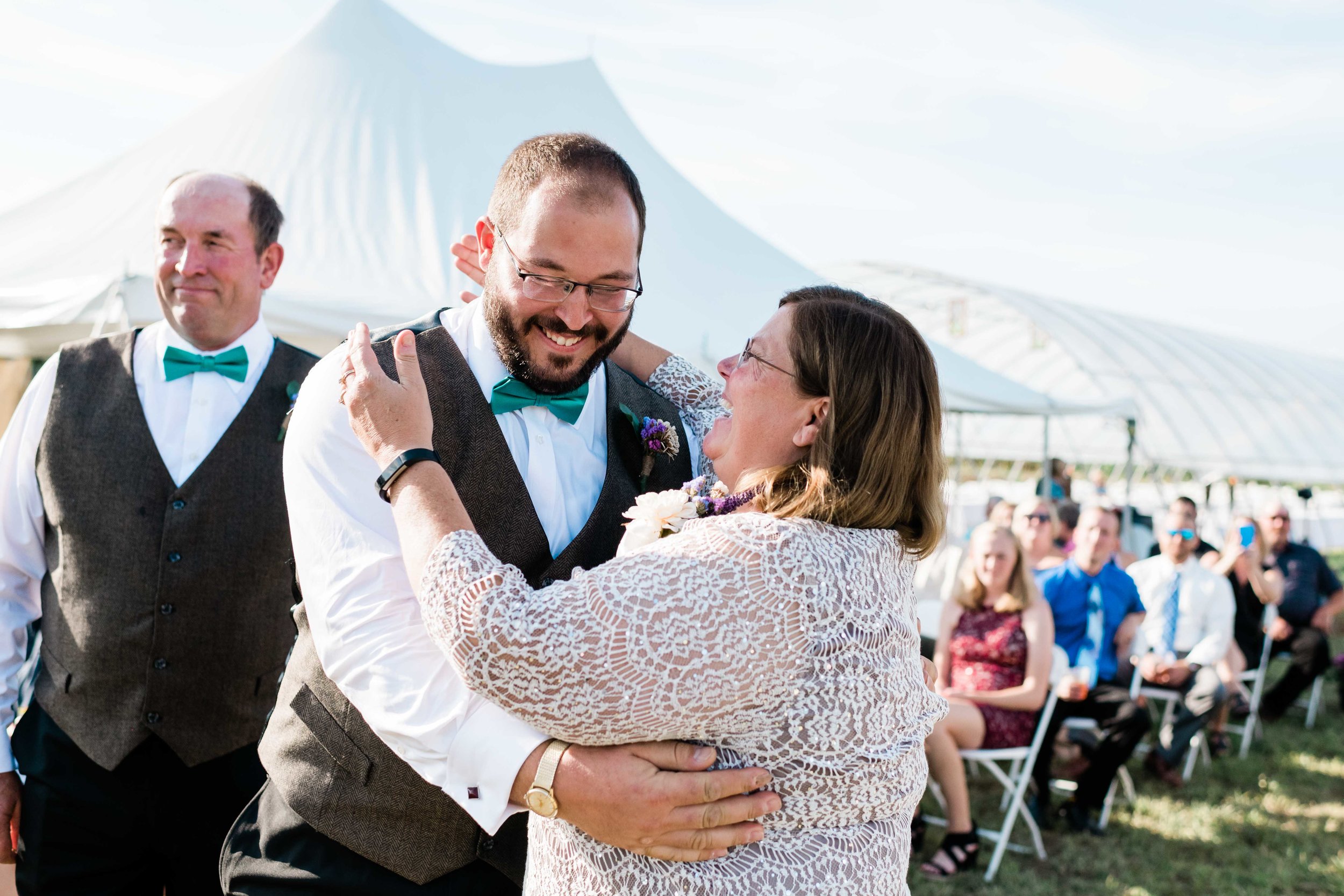 Groom and his mom share a laugh and a hug after they walk down the aisle together
