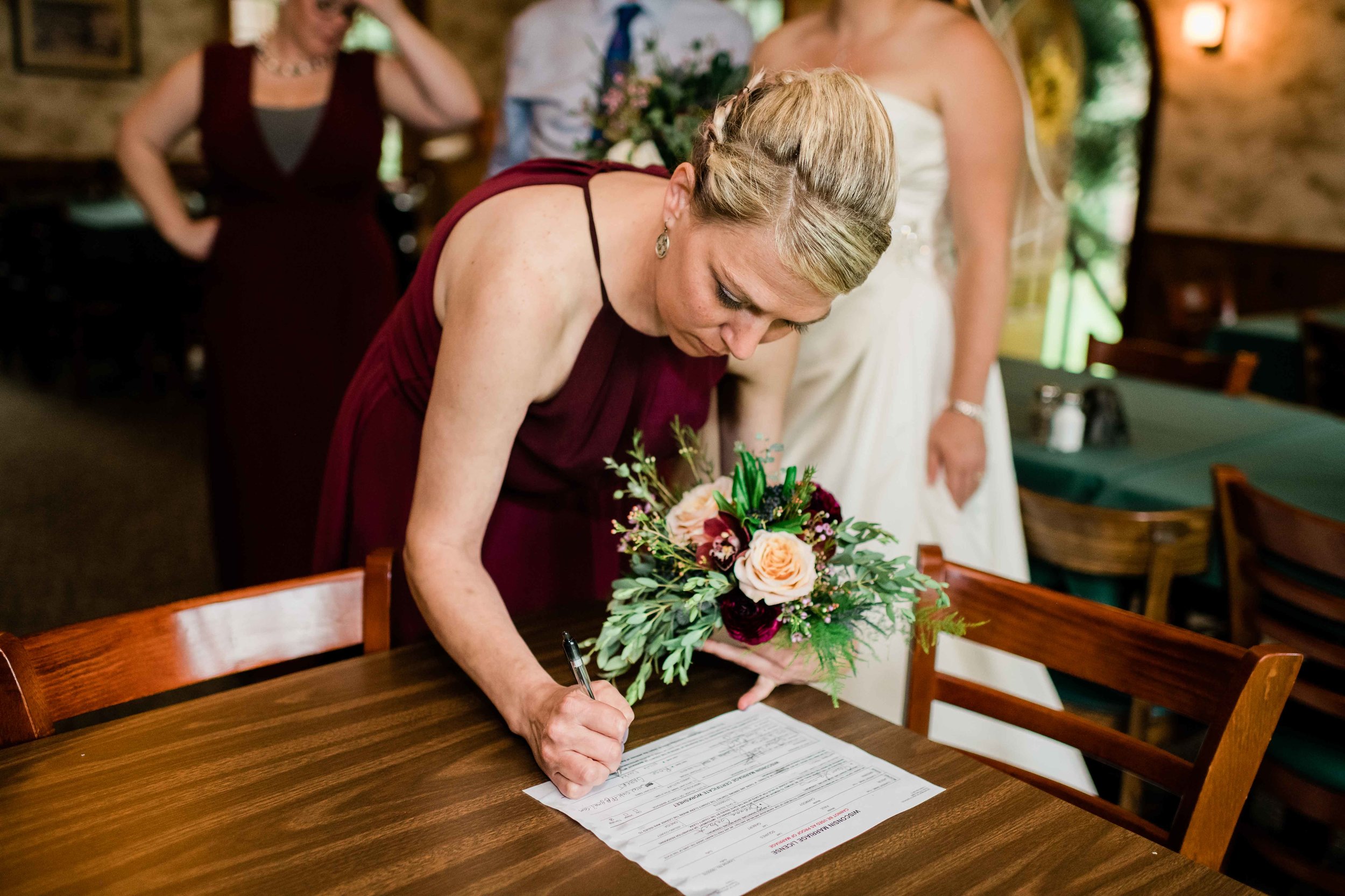 Bridesmaid signs marriage license