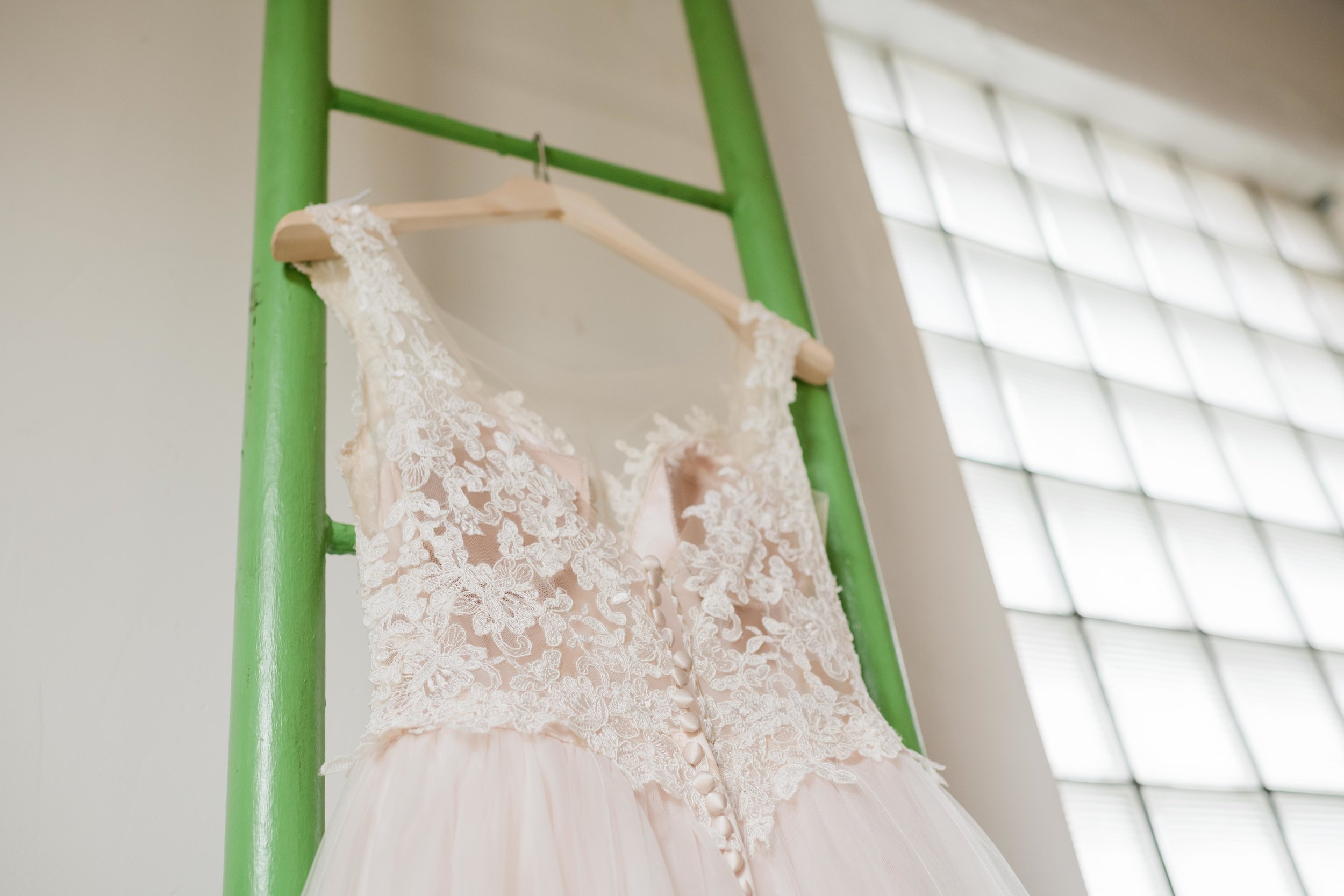 Bridal gown hanging on ladder