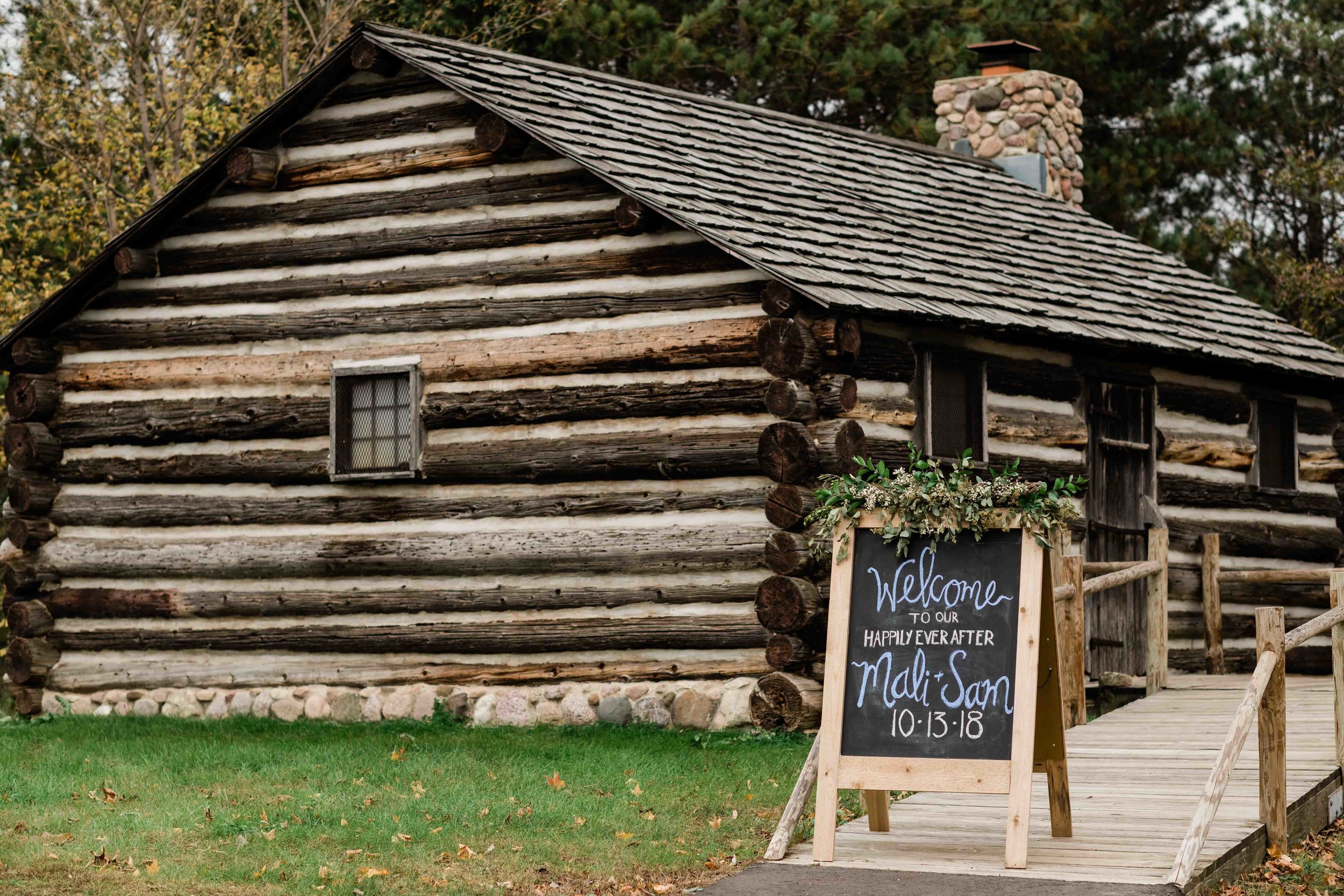 Wedding sign in front of log cabin