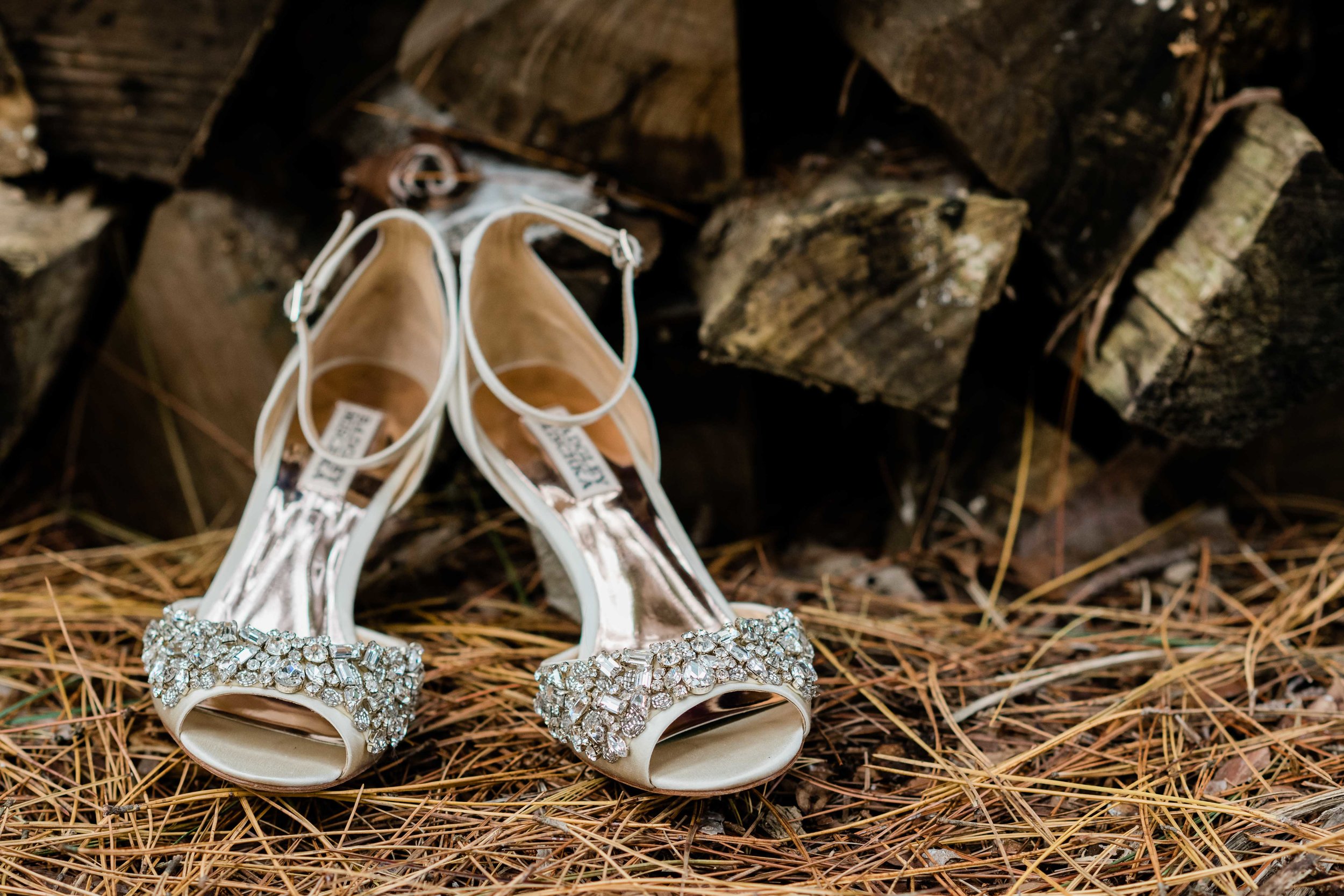 Badgley Mischka bridal shoes sitting on pine needles