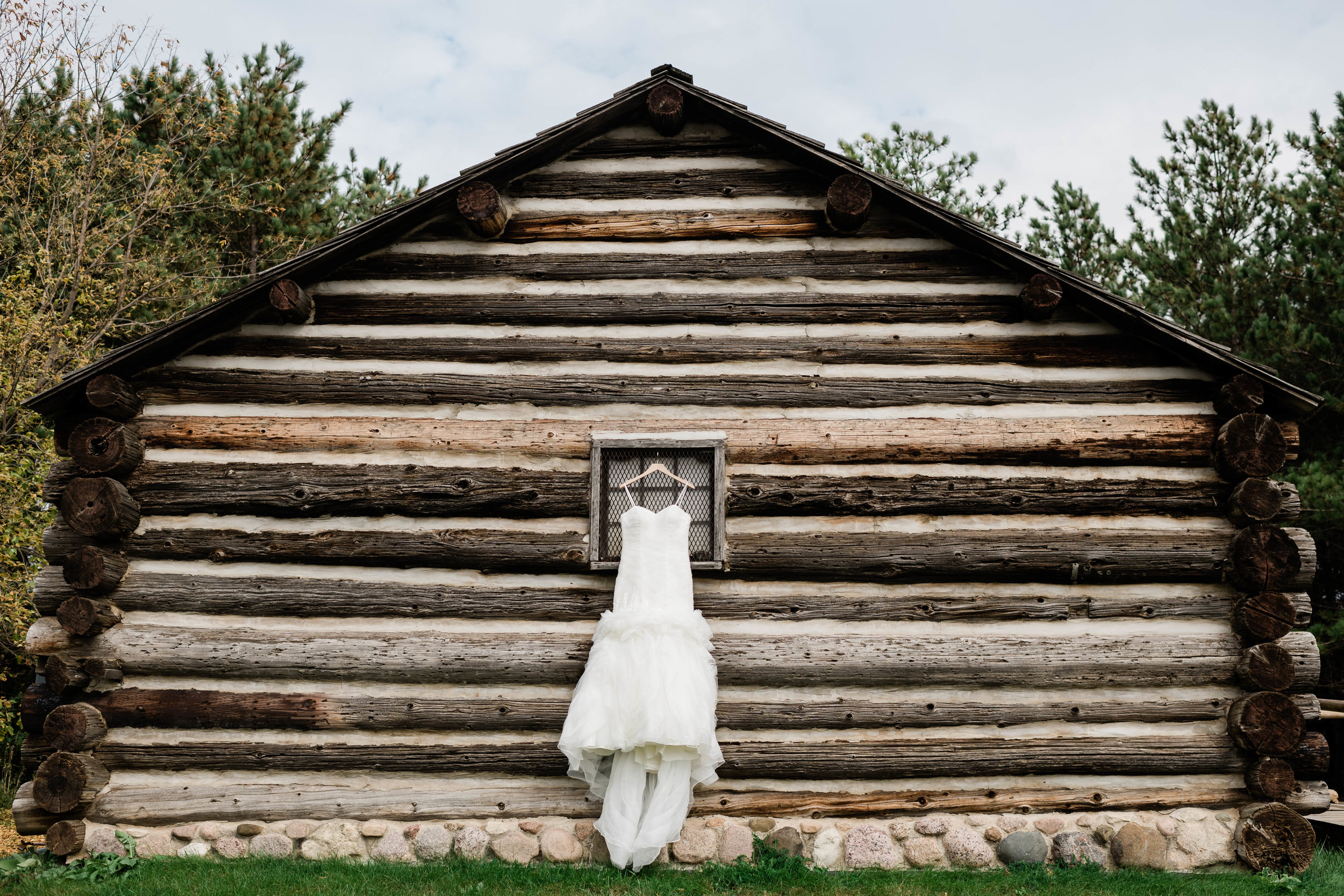 Wedding dress hanging on log cabin