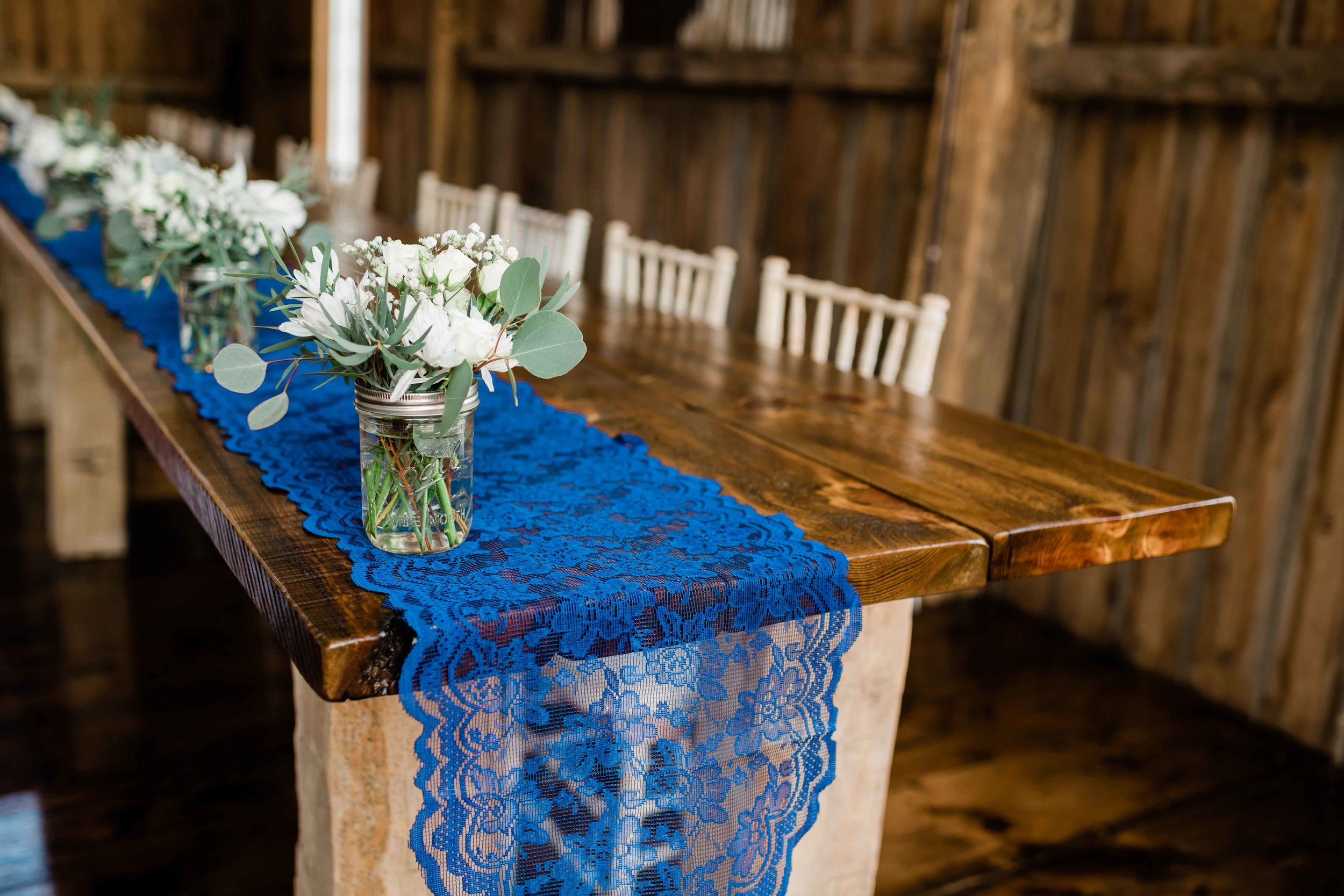 Blue lace table runner under jars of flowers