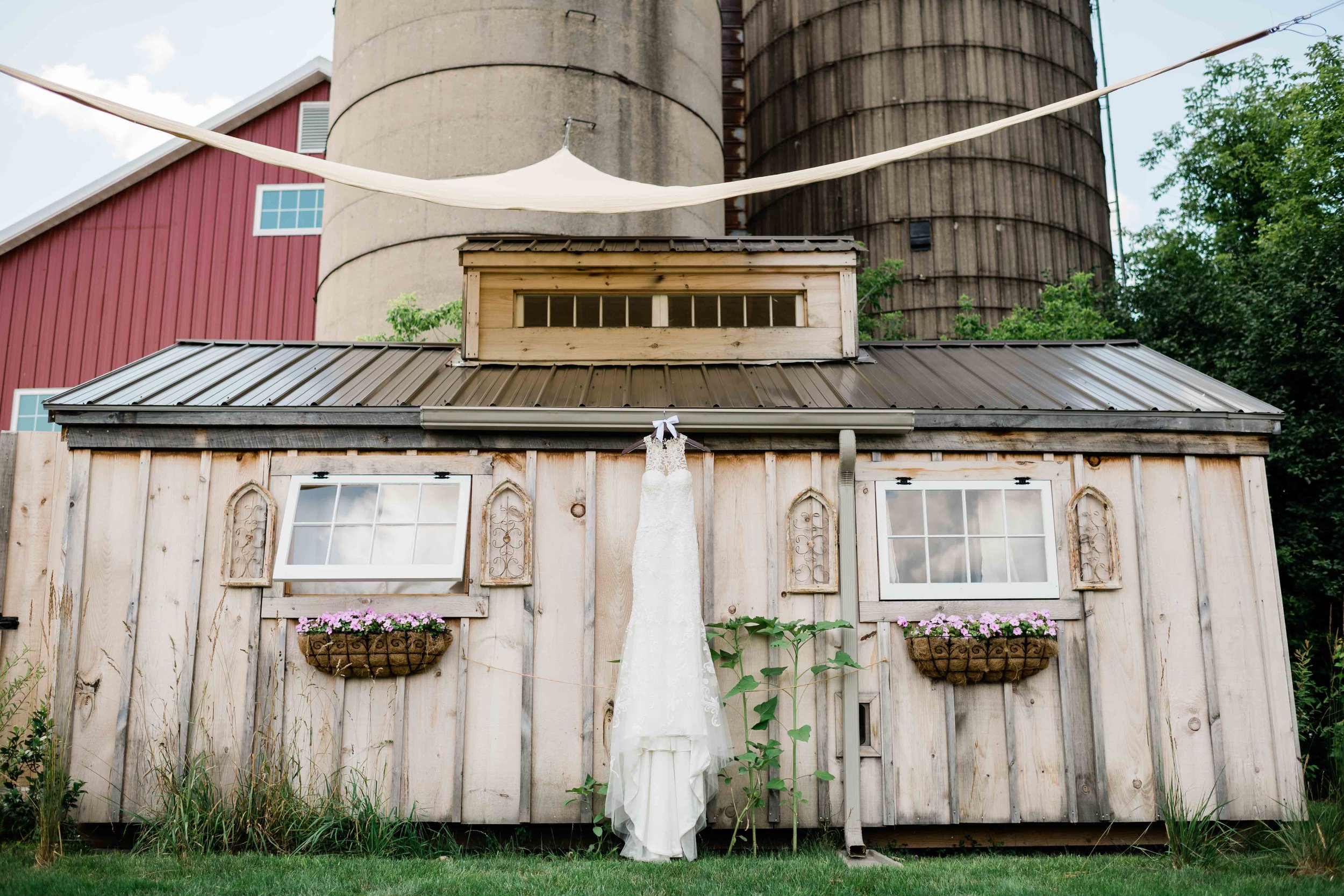 Wedding dress hanging from She Shed at Cupola Barn