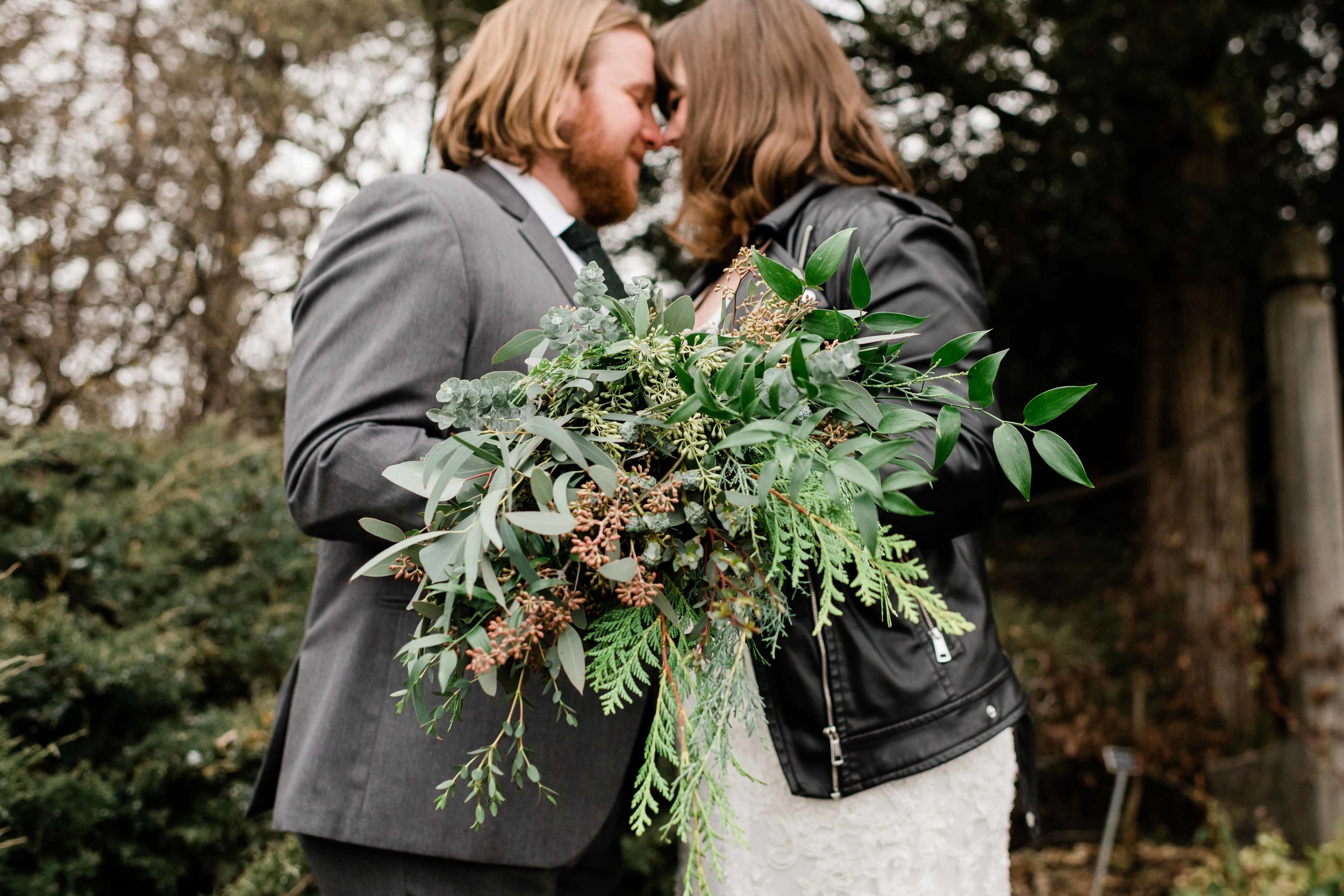 Bride and groom holding bouquet together