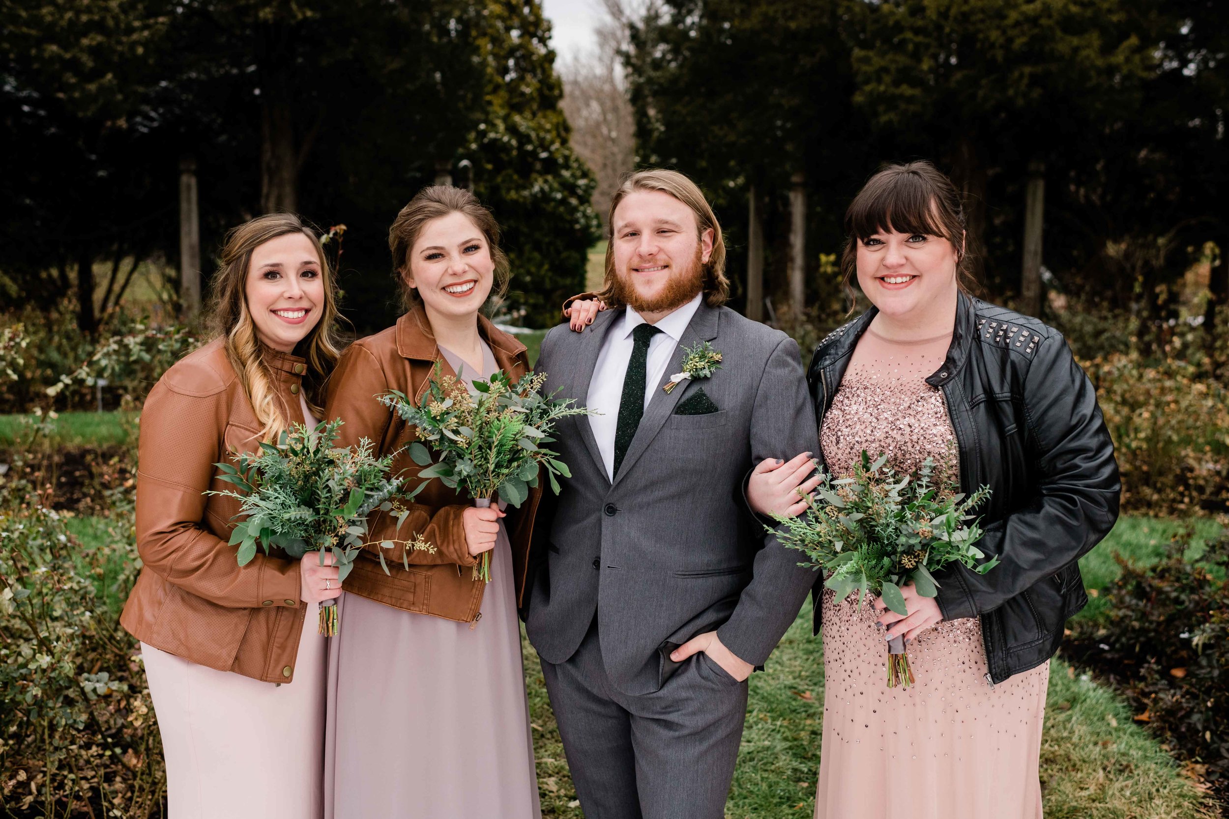 Groom poses with bridesmaids