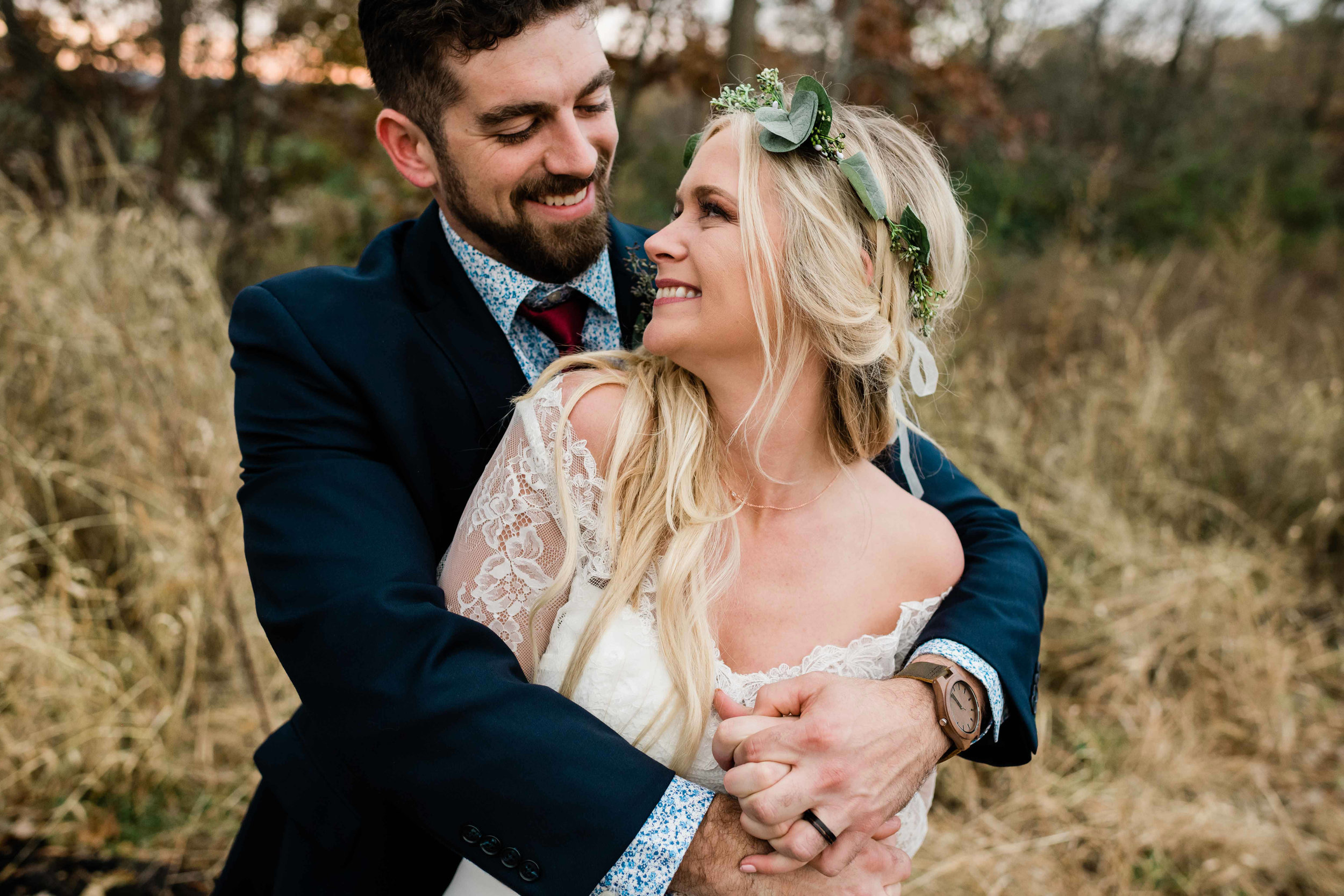 Groom wraps his arm around bride from behind