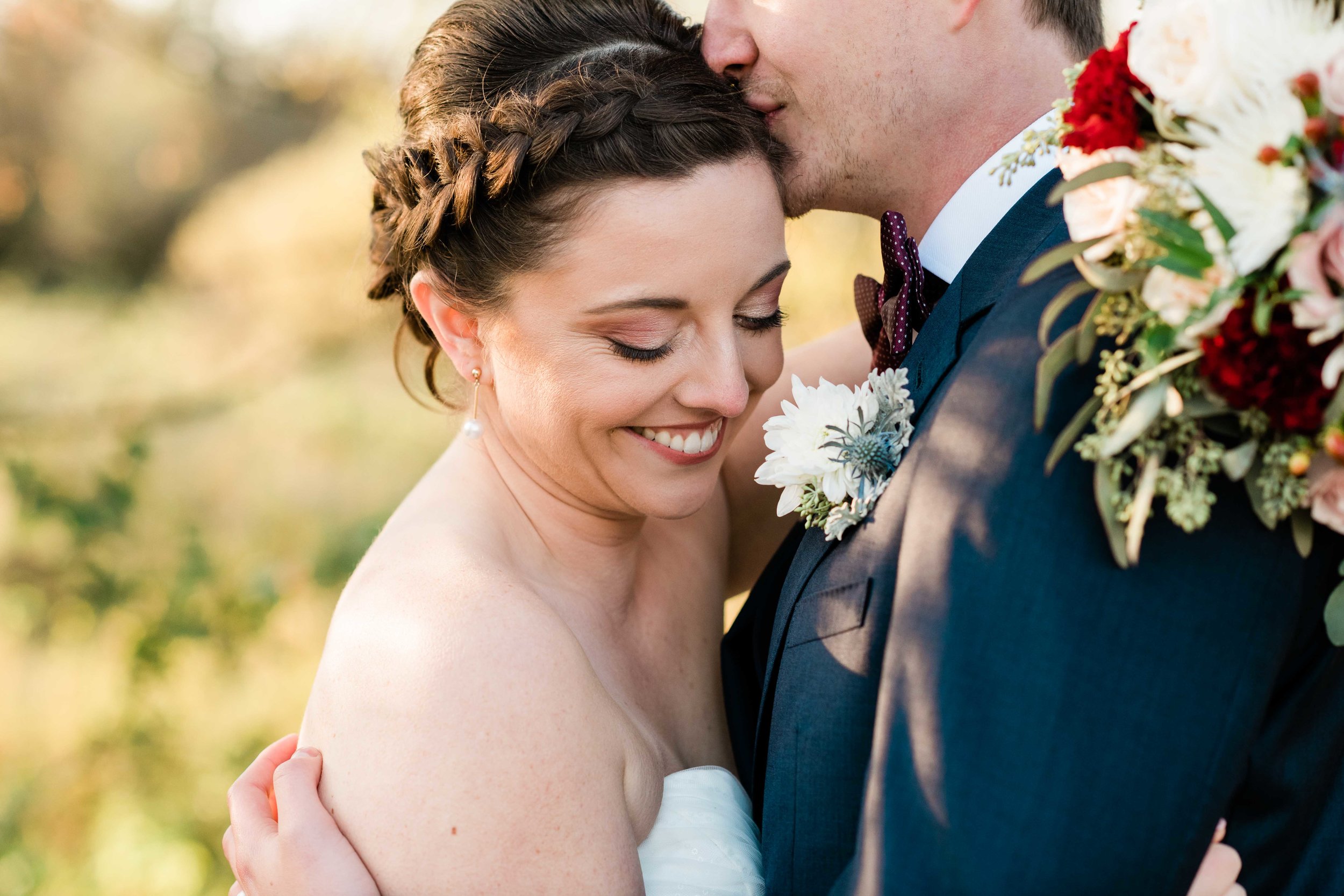 Groom kissing bride's head