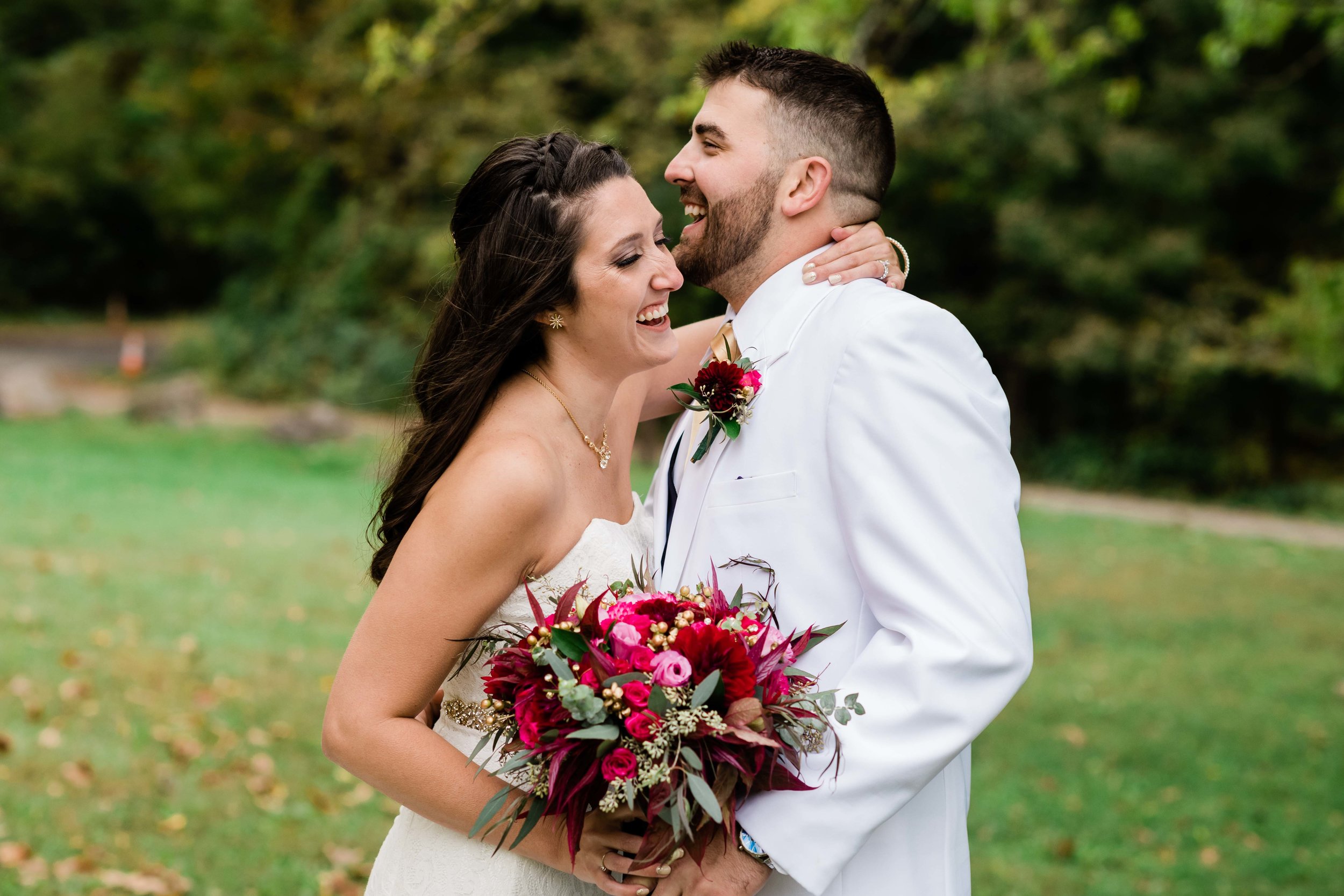 Bride and groom laugh as they embrace each other