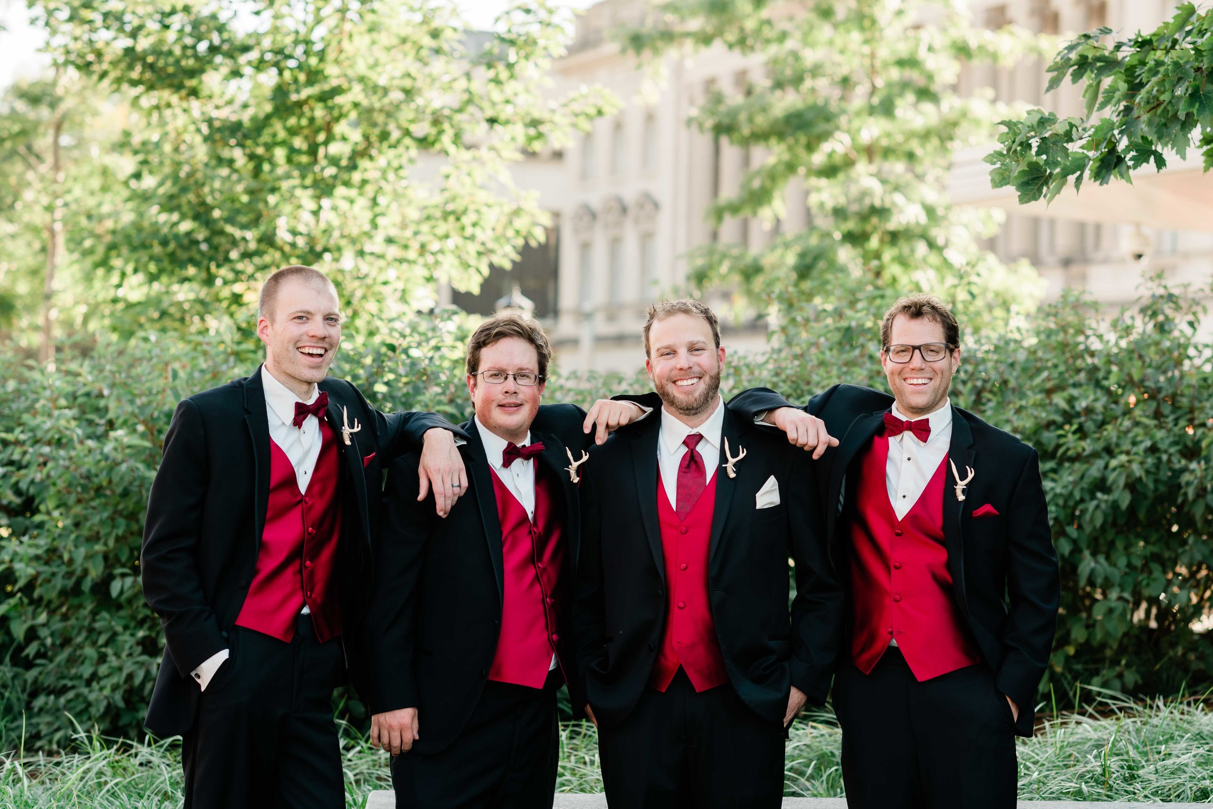 Groom and groomsmen rest their arms on each other's shoulders