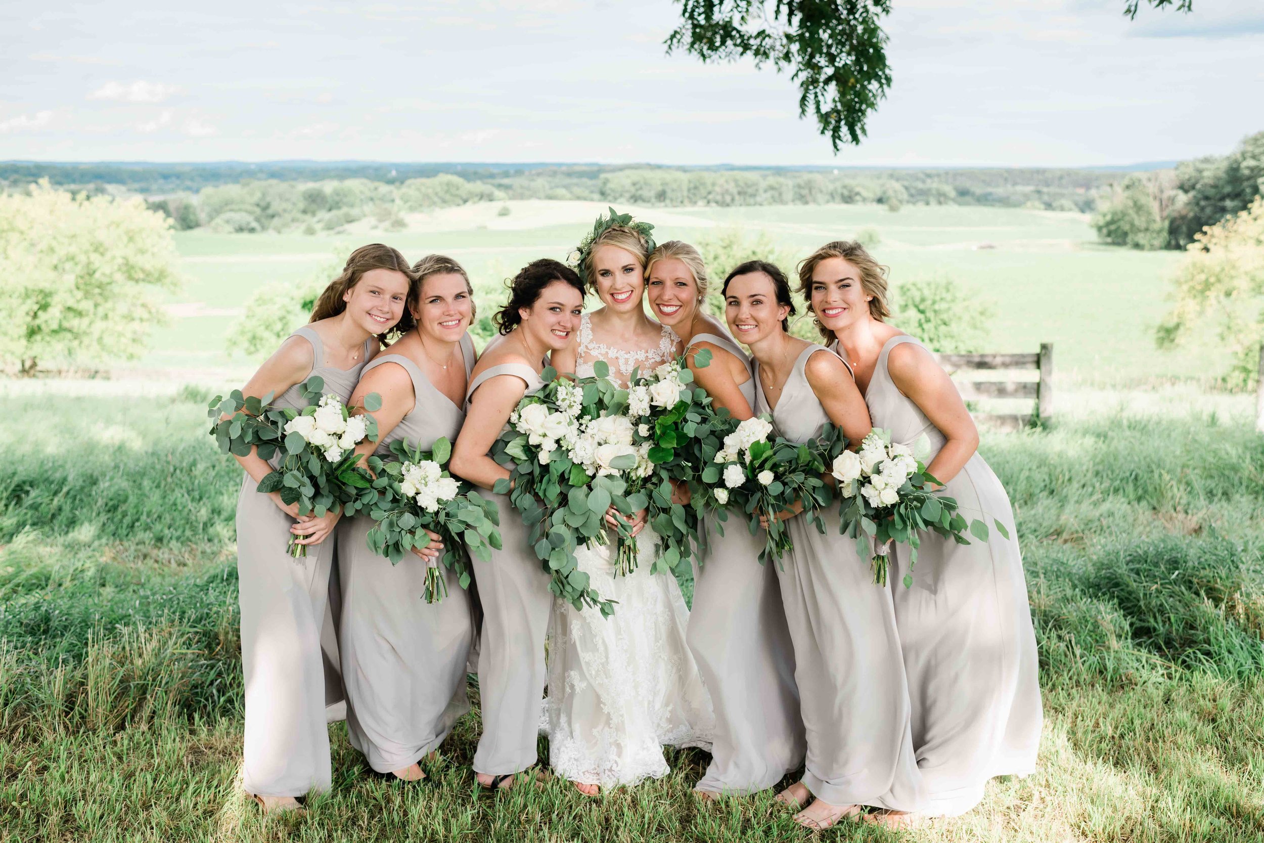 Bridesmaids lean into bride