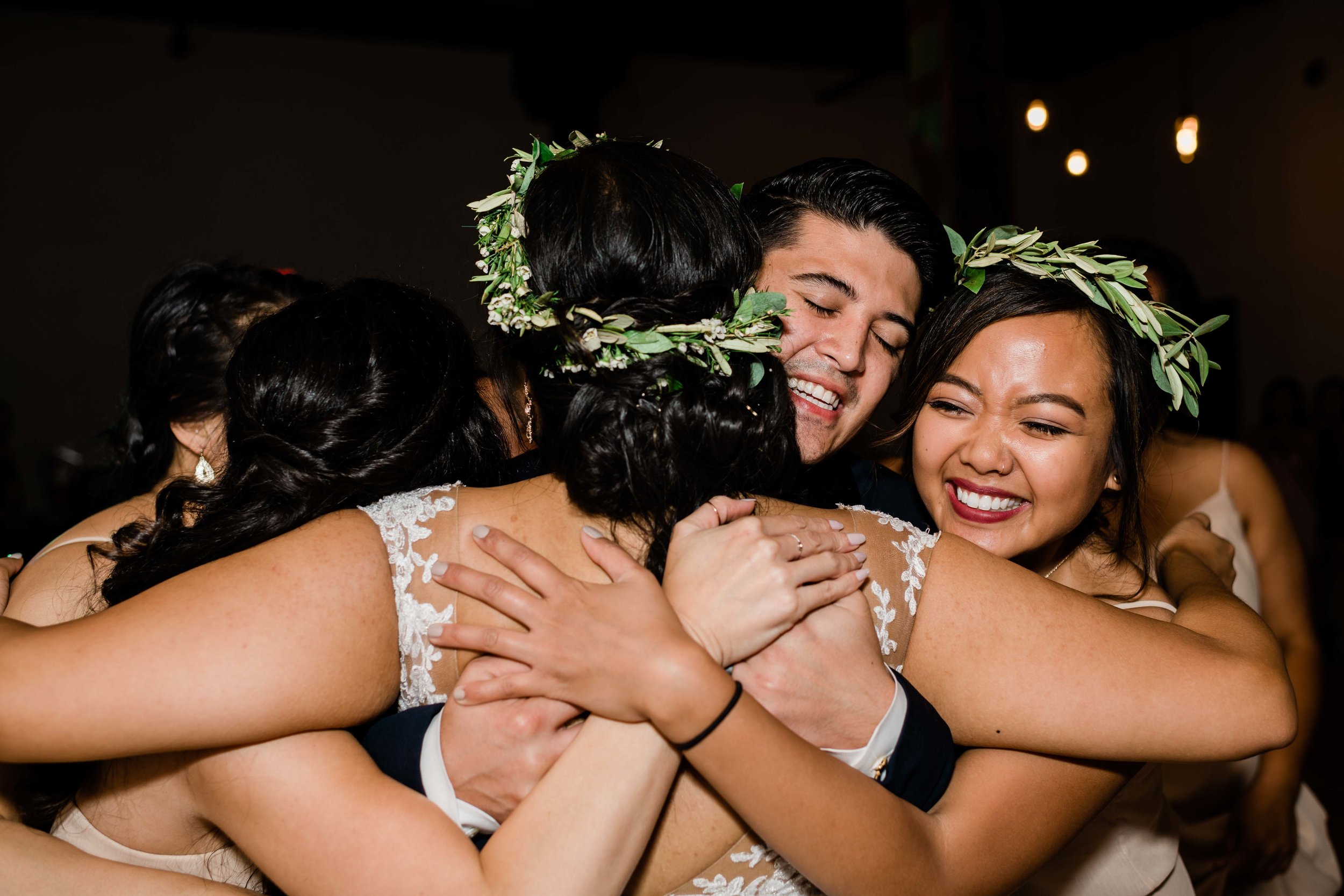 Groom hugs bridesmaids