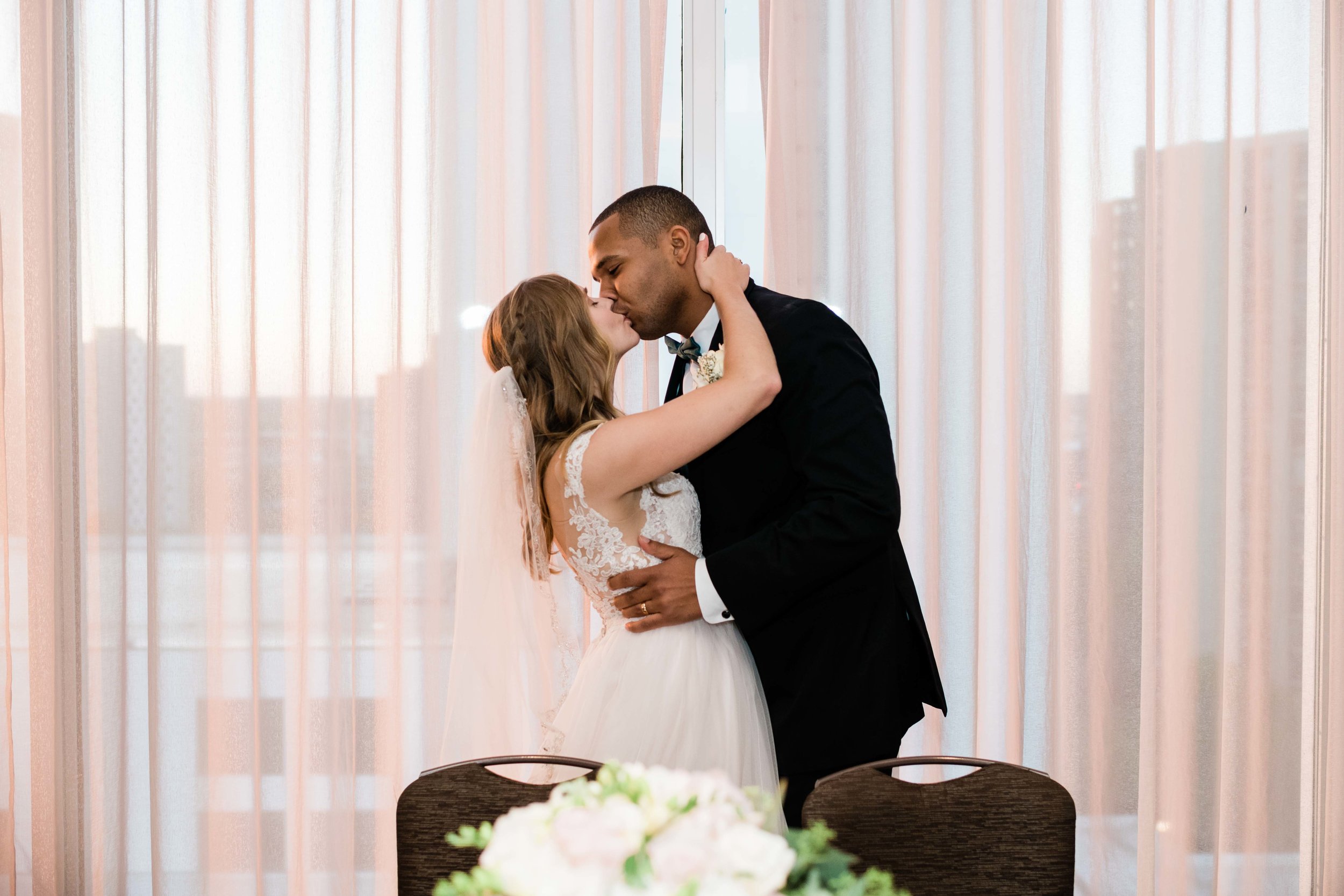 Bride and groom kiss at sweetheart table