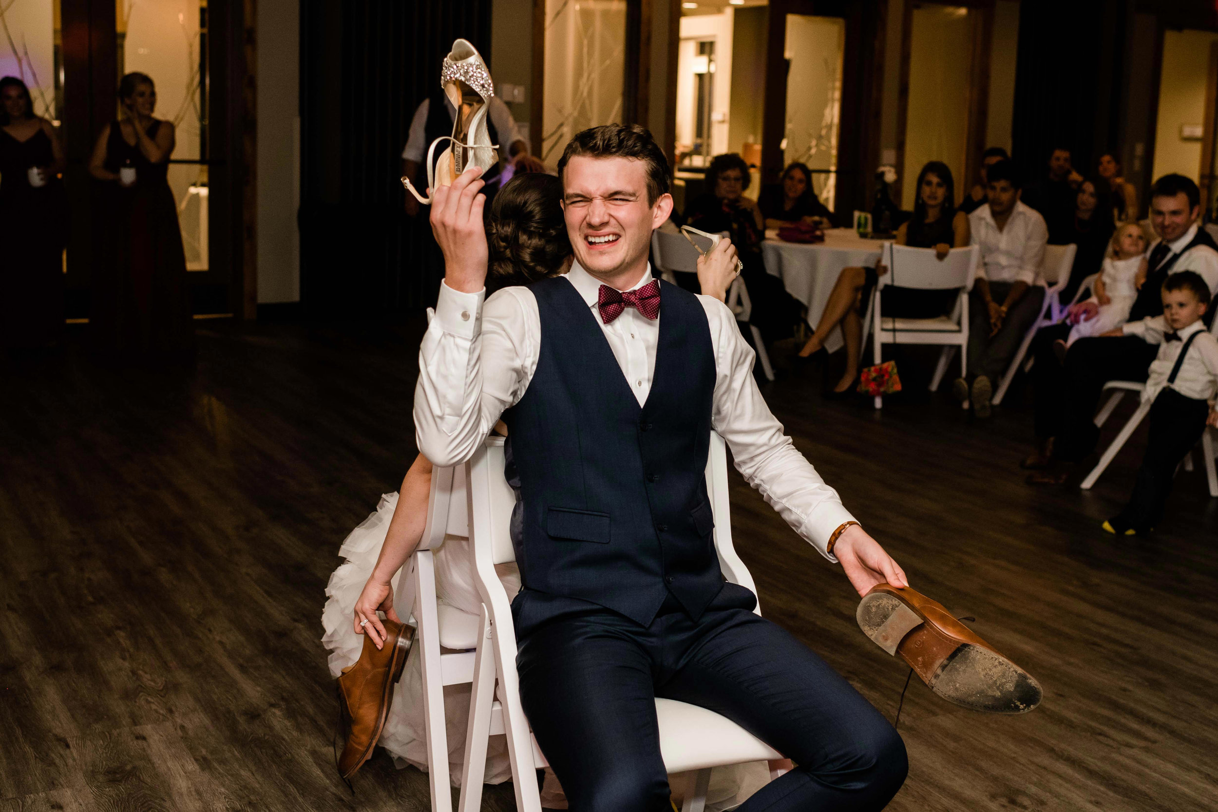 Groom playing the shoe game with bride