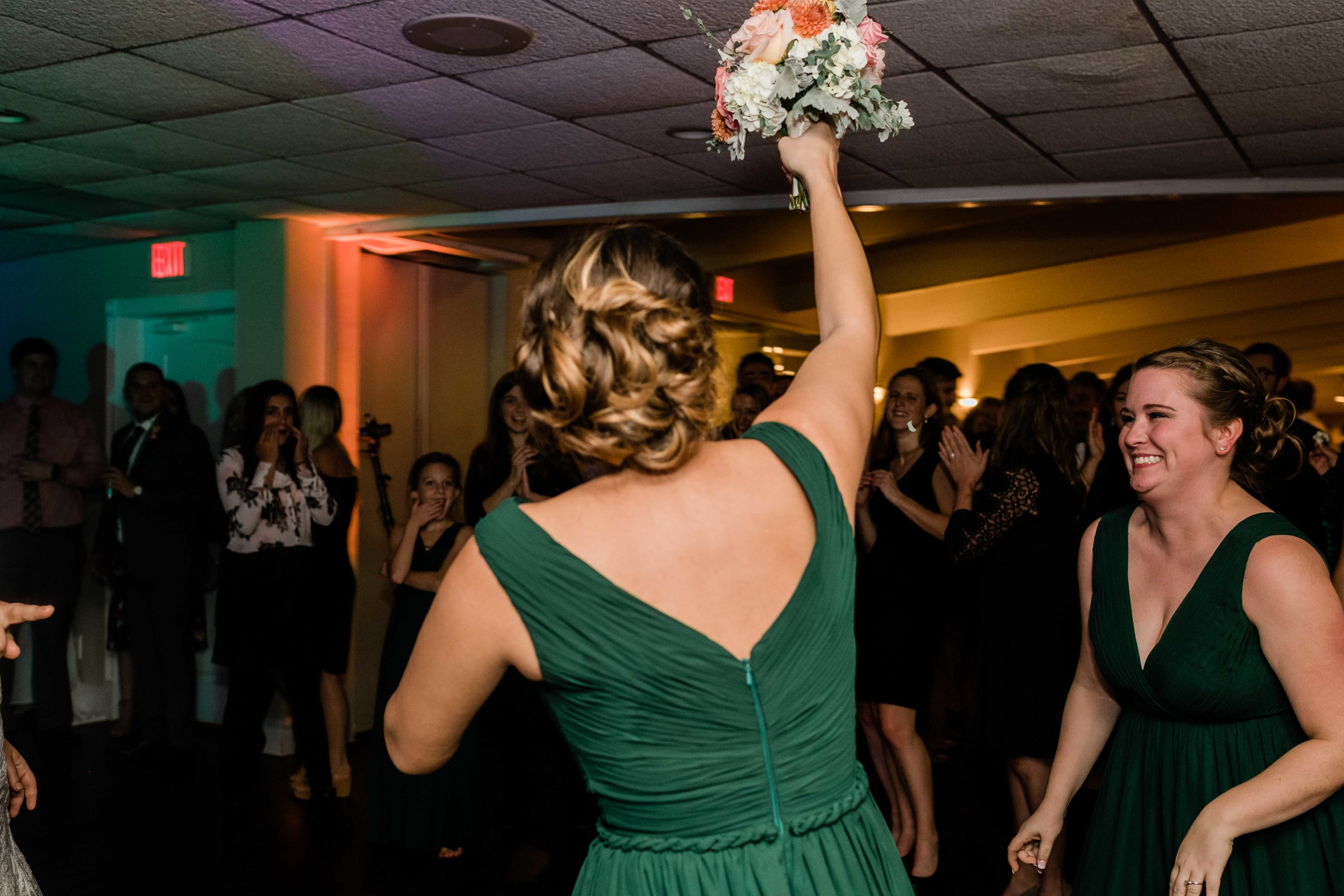 Bridesmaid catches bouquet during bouquet toss