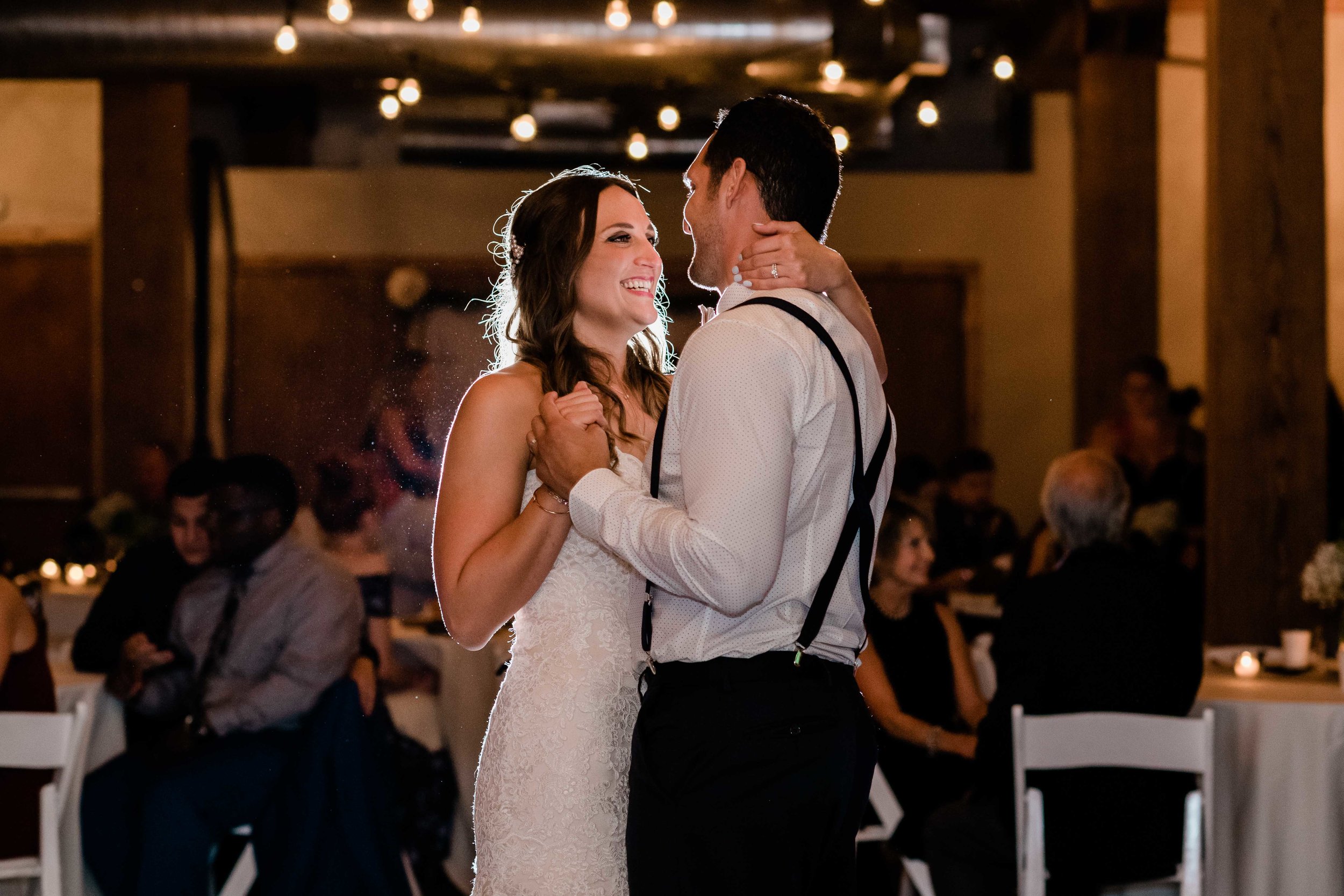 Bride smiles at groom during their first dance