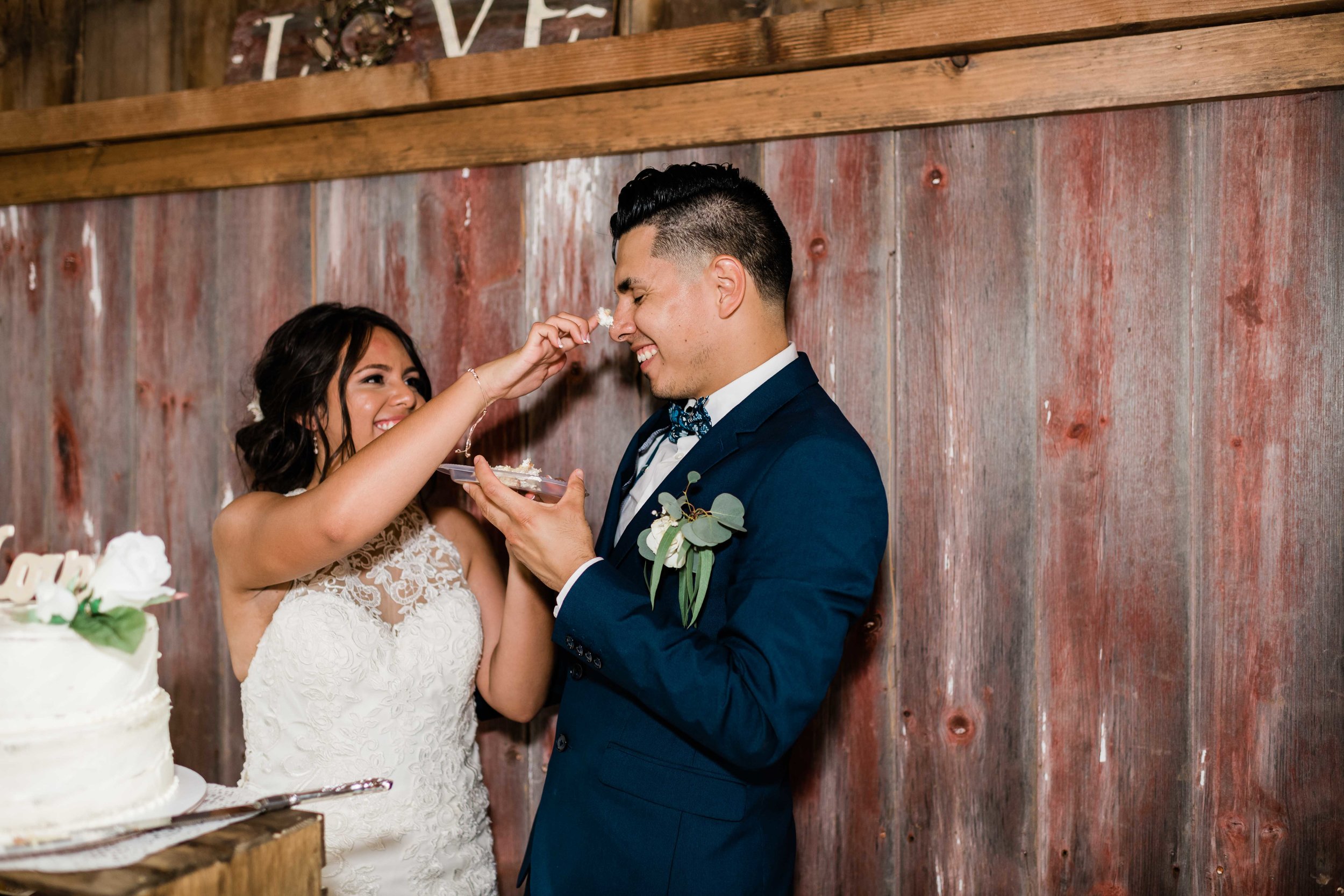 Bride putting cake on groom's nose