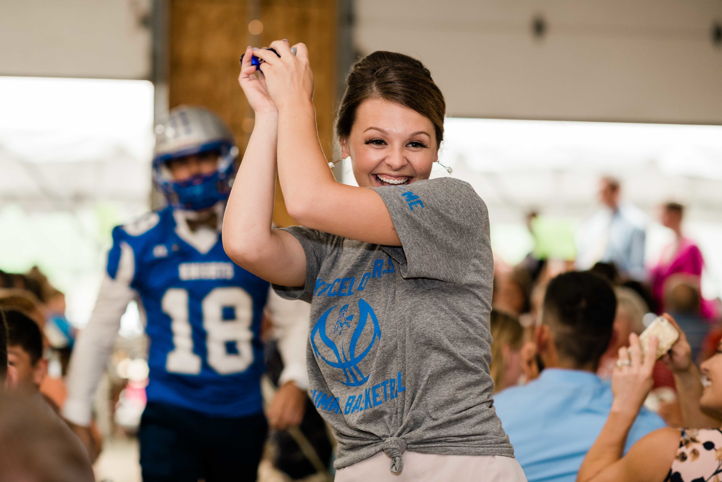 Groomsman and bridesmaid play football during grand entrance