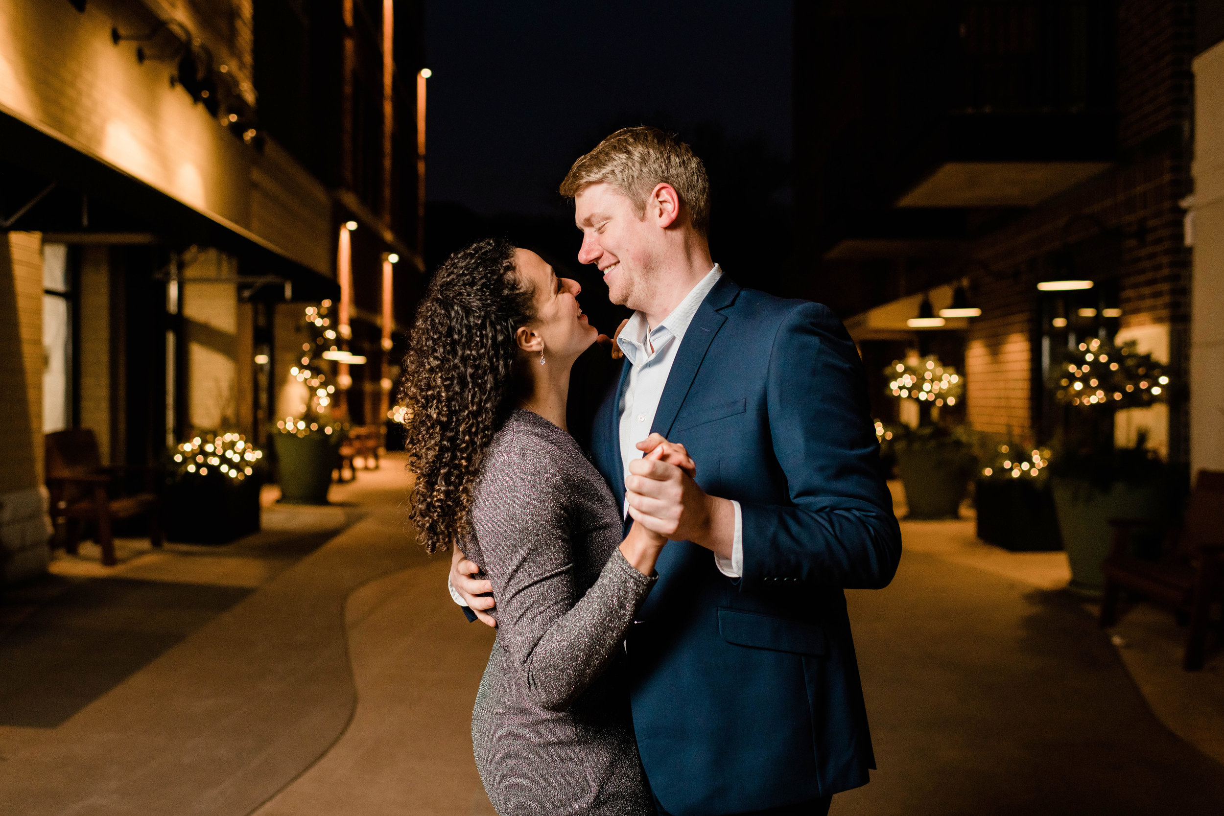 Engaged couple dancing in the streetlights