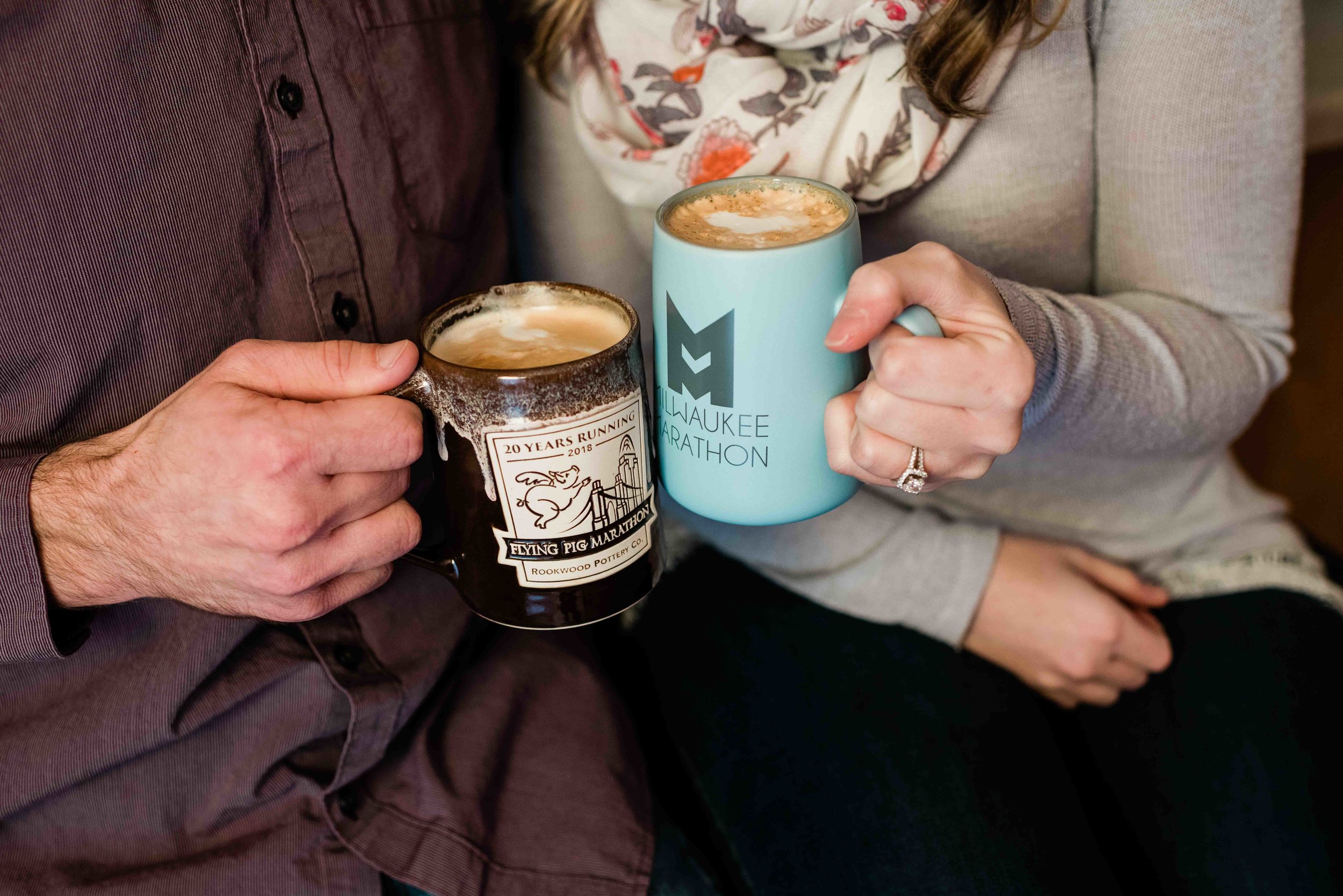 Engaged couple holds coffee mugs