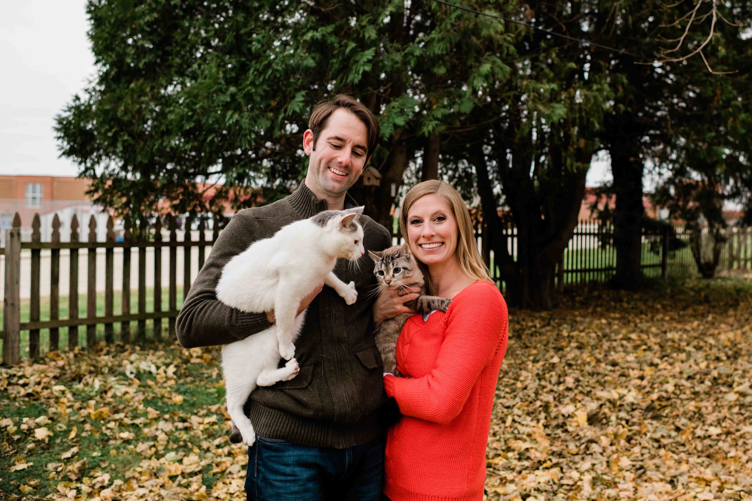 Engaged couple holding their cats