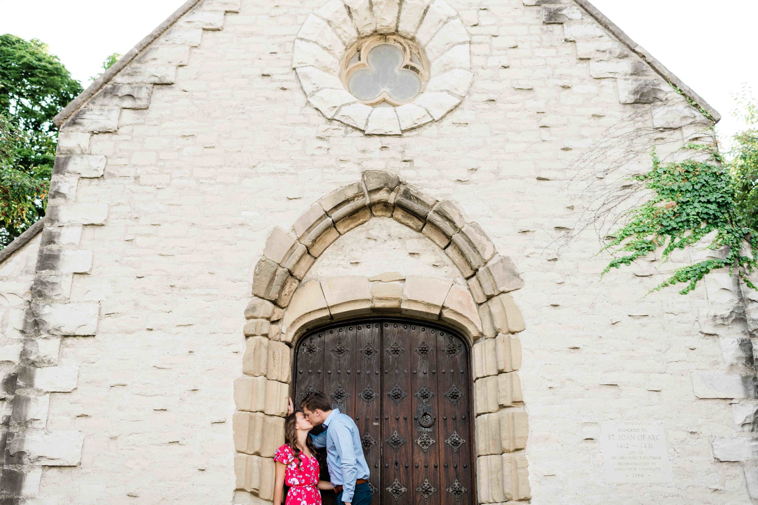 Engaged couple kissing in front of a garden house