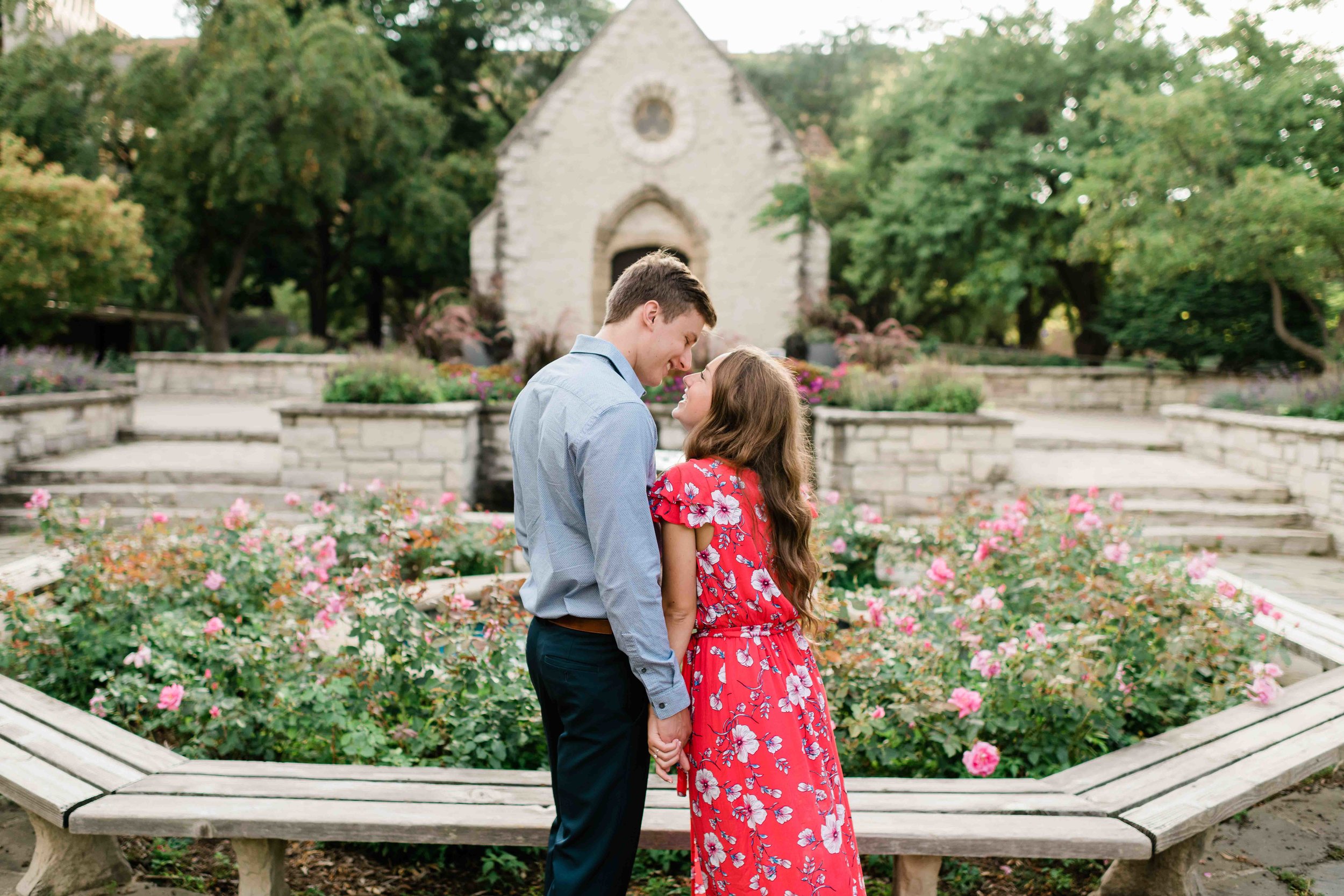 Engaged couple kissing in a garden