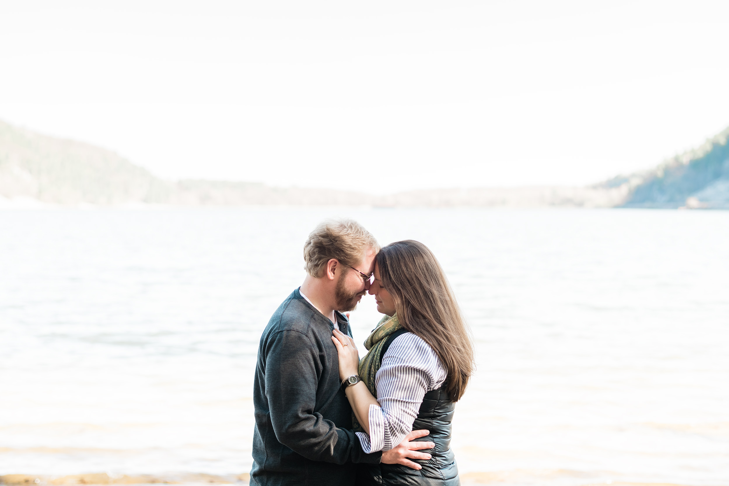 Engaged couple forehead to forehead in front of Devil's Lake