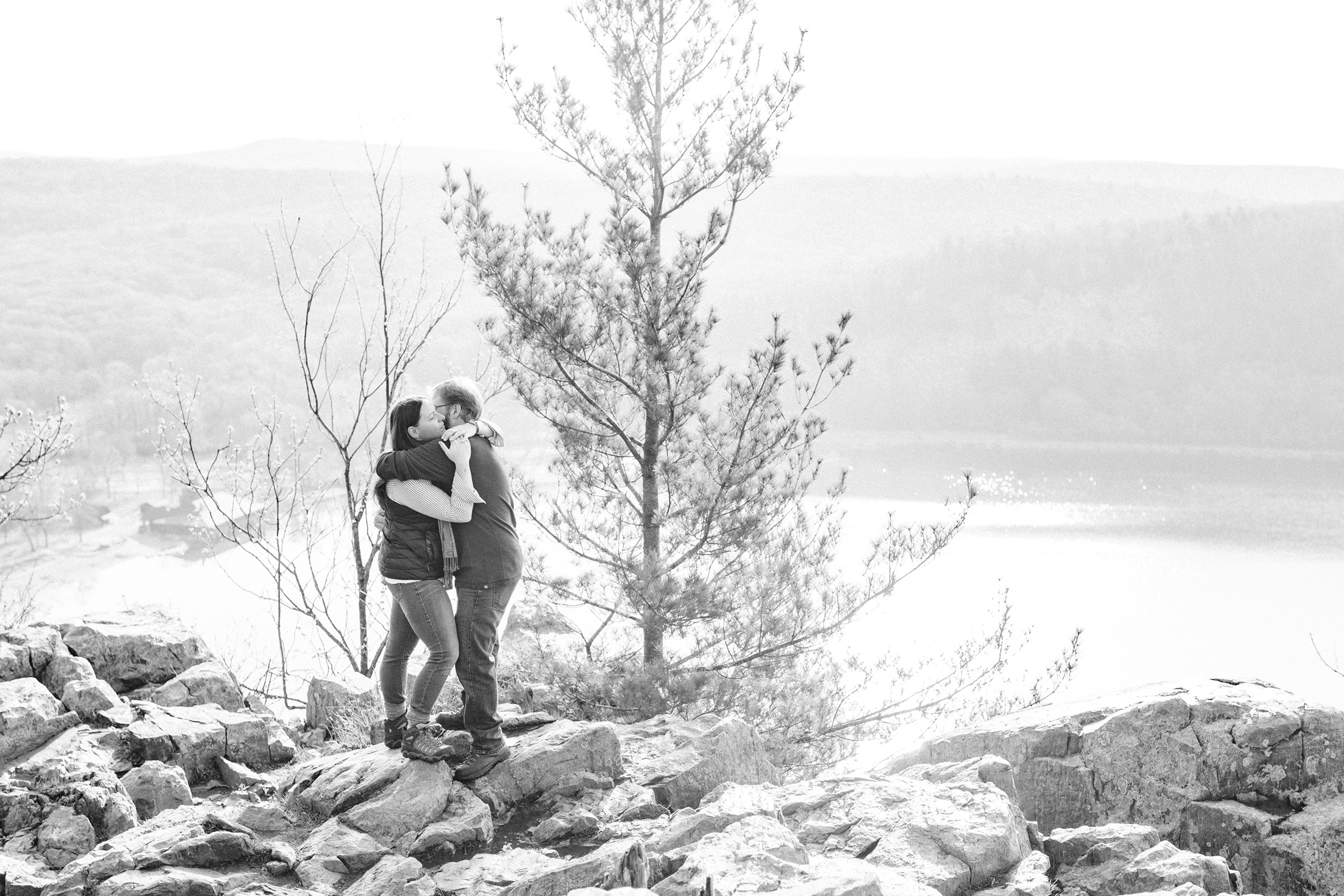 Engaged couple hugging at the peak of Devil's Lake State Park