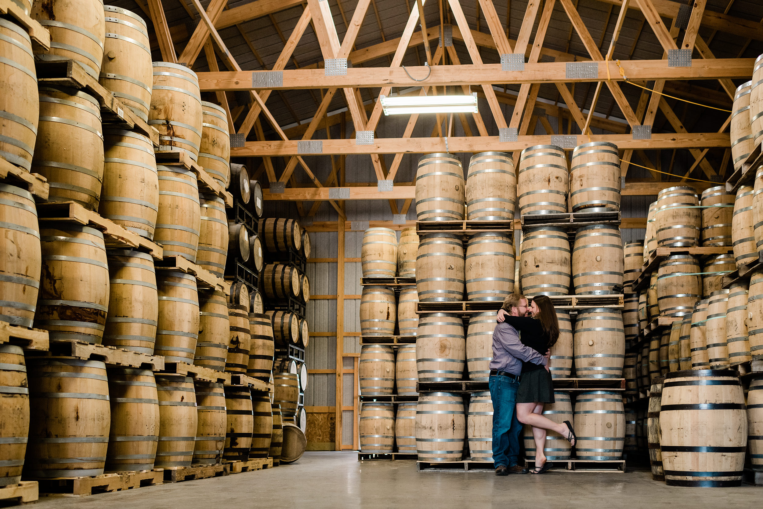 Engaged couple in the rickhouse at Driftless Glen Distillery