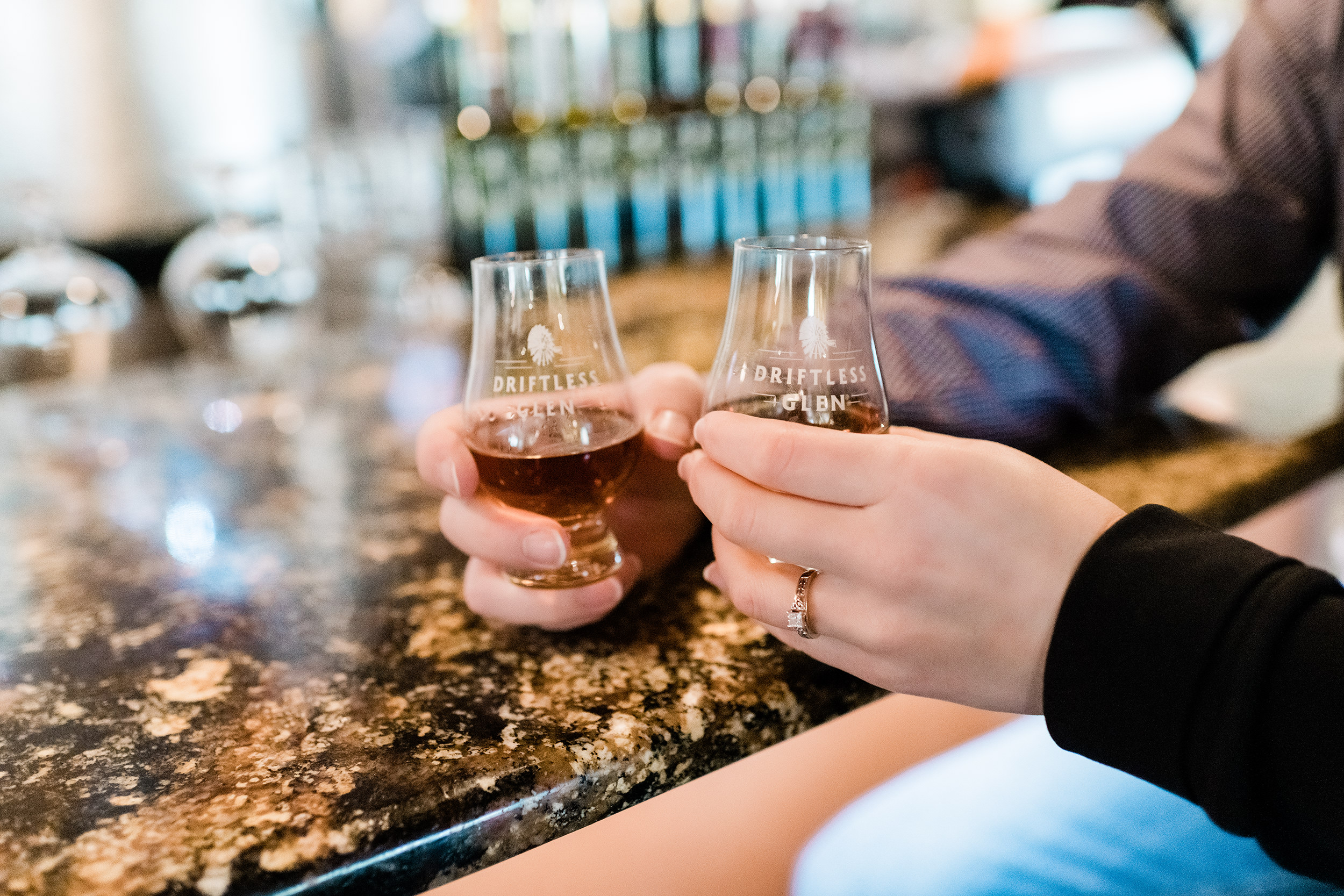 Engaged couple drinking bourbon at Driftless Glen Distillery in Baraboo