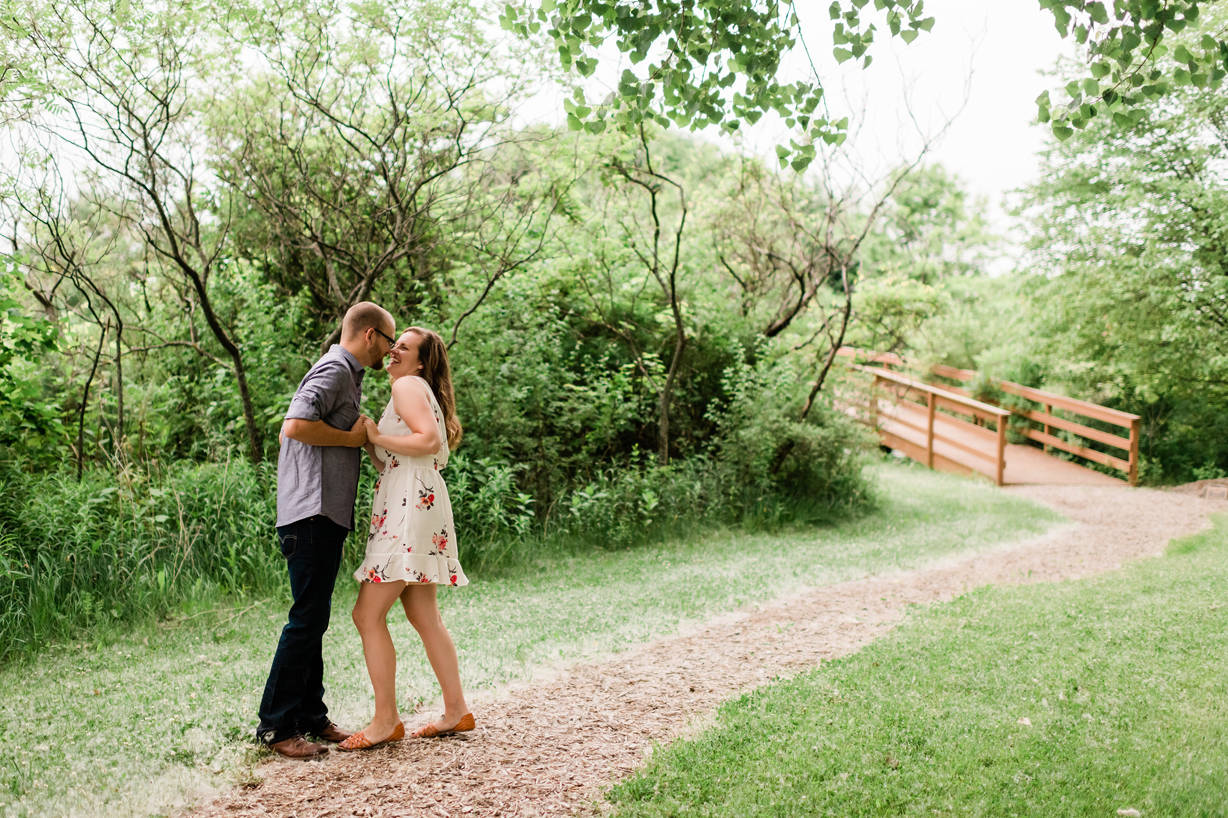Engaged couple by a bridge