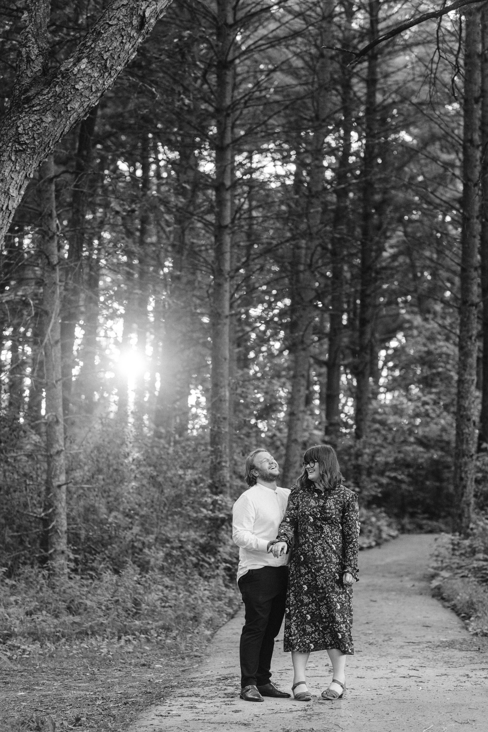 Engaged couple laughing in the woods