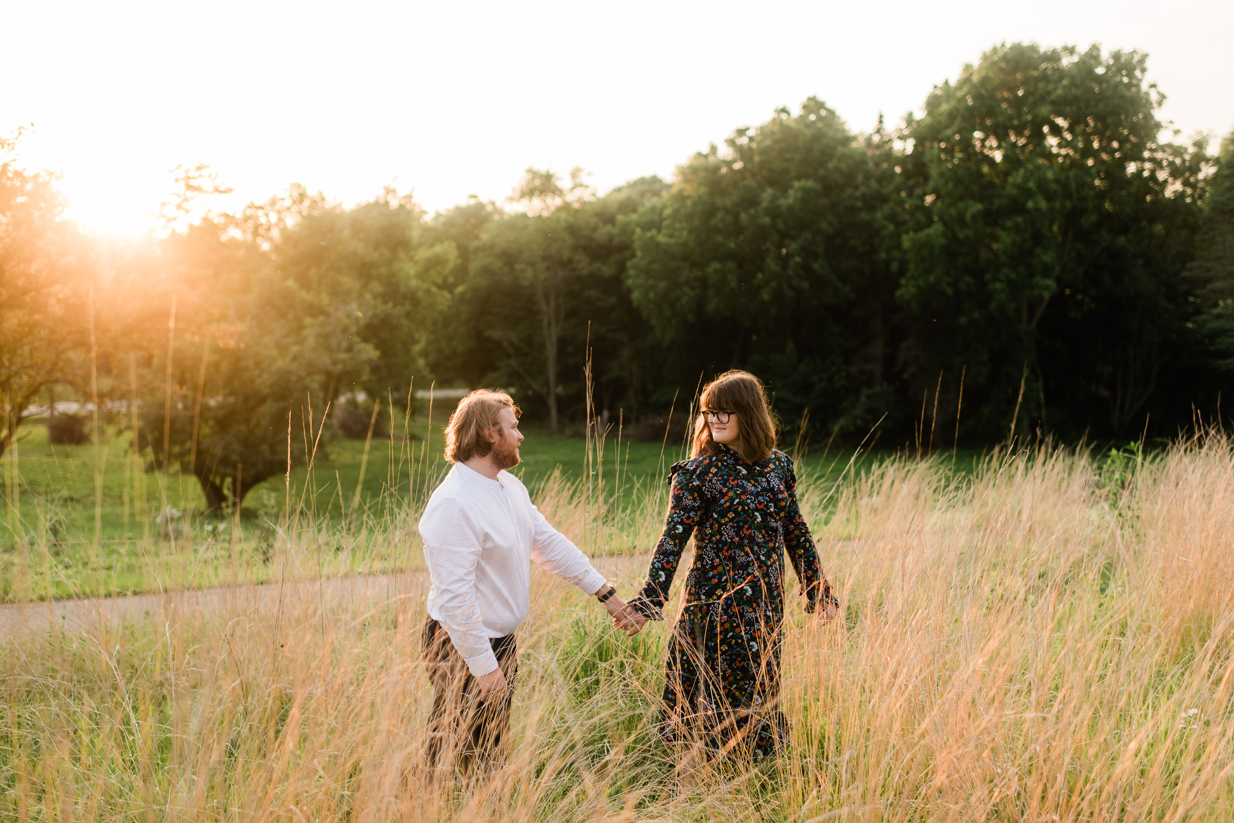 Engaged couple walking in a field