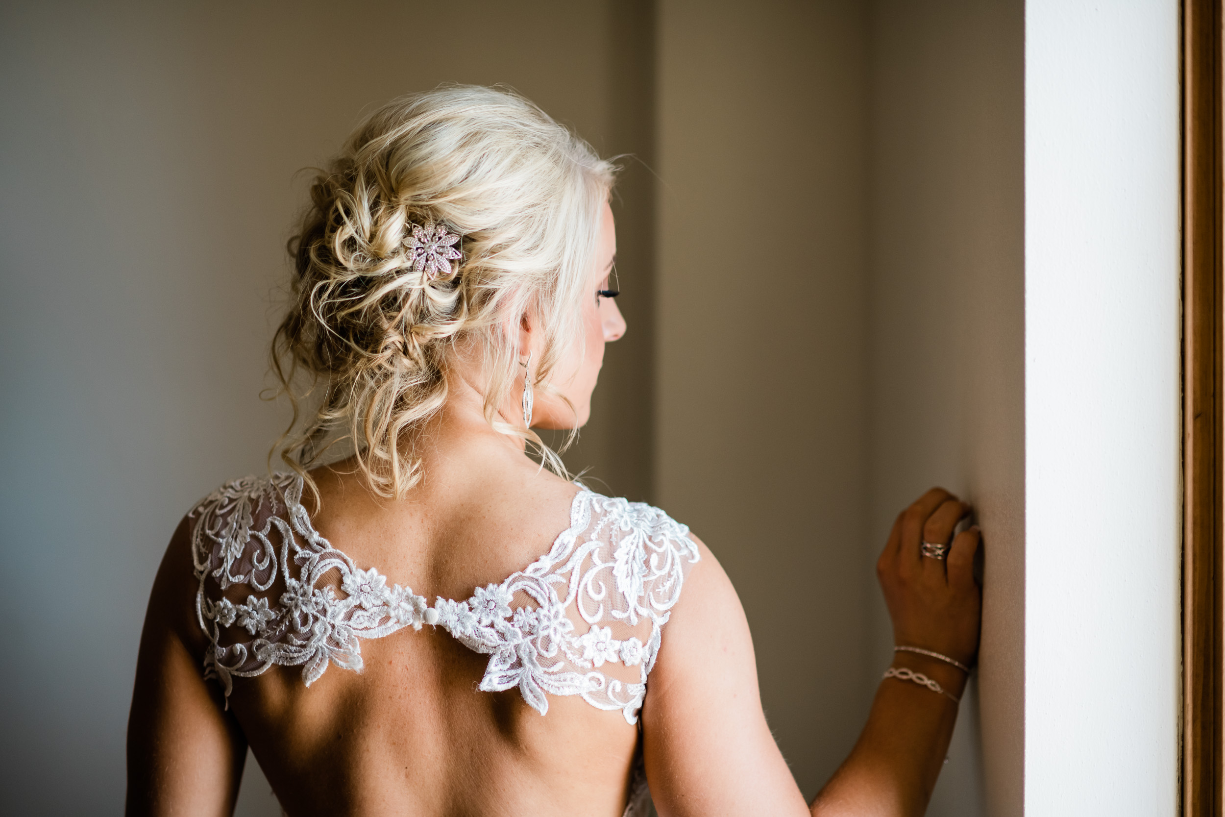 Back of bride's dress as she looks out the window