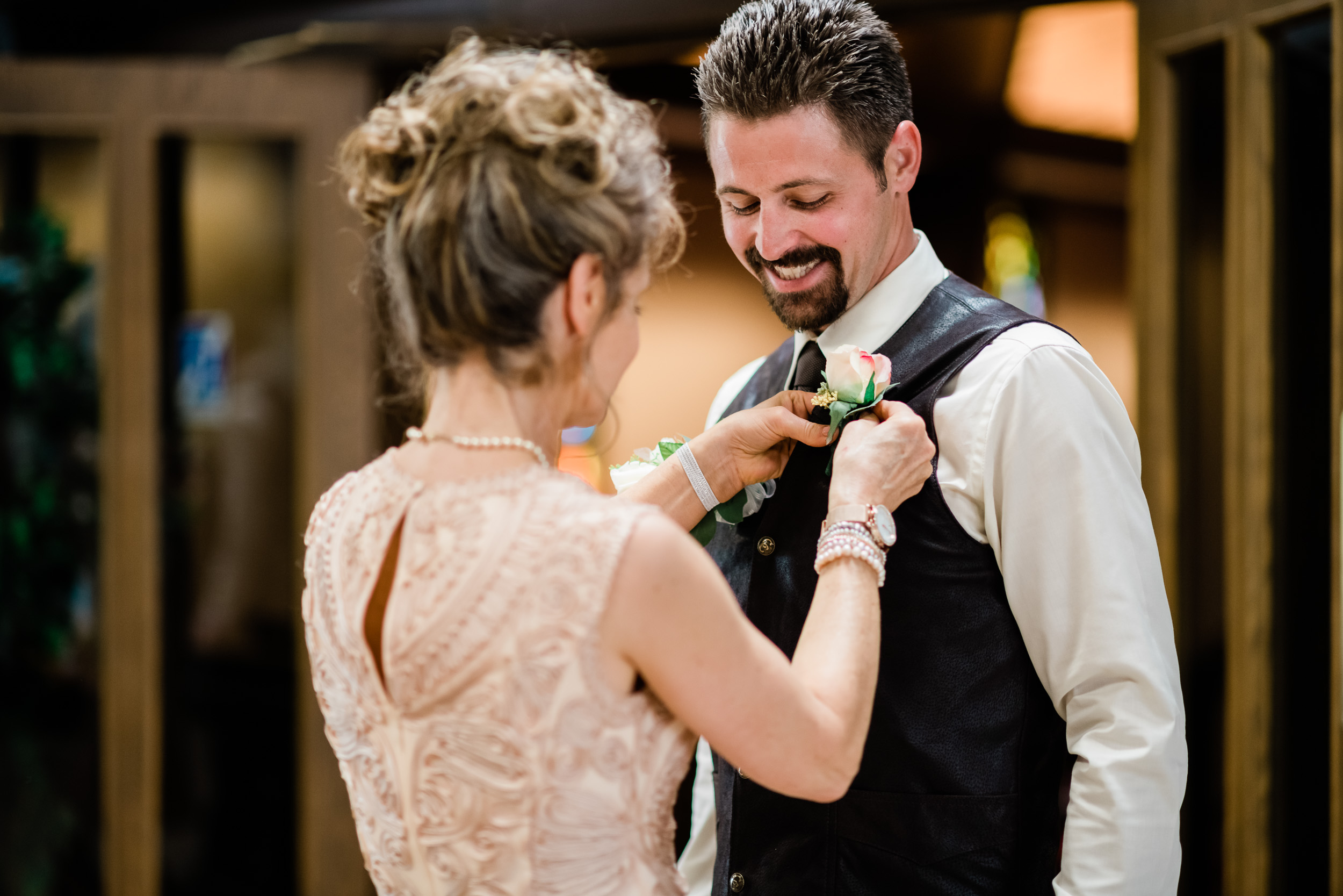 Mother of groom pinning on his boutonnière