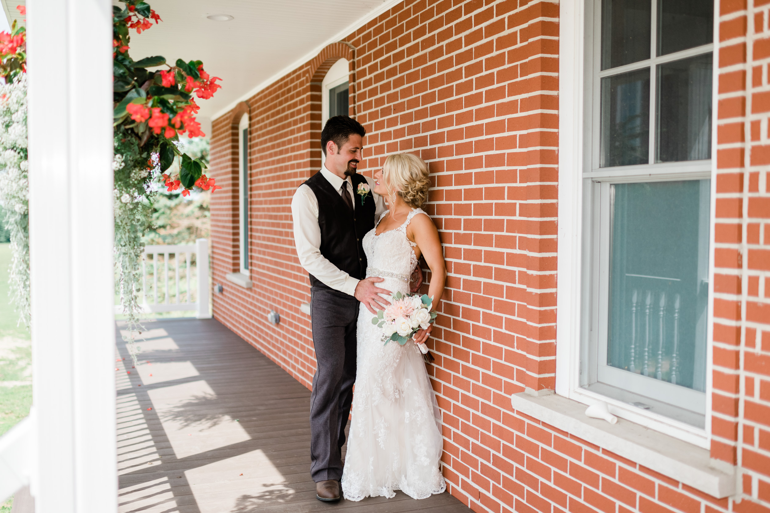 Bride and groom looking at each other on front porch
