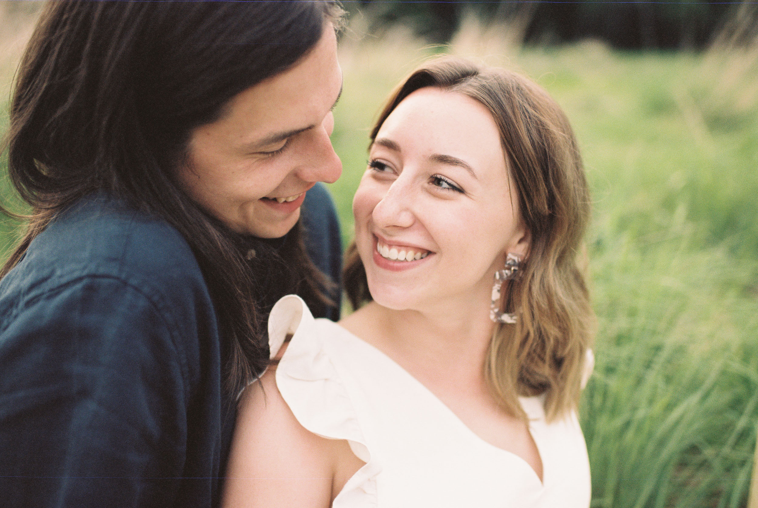 Engaged couple sitting and smiling at each other