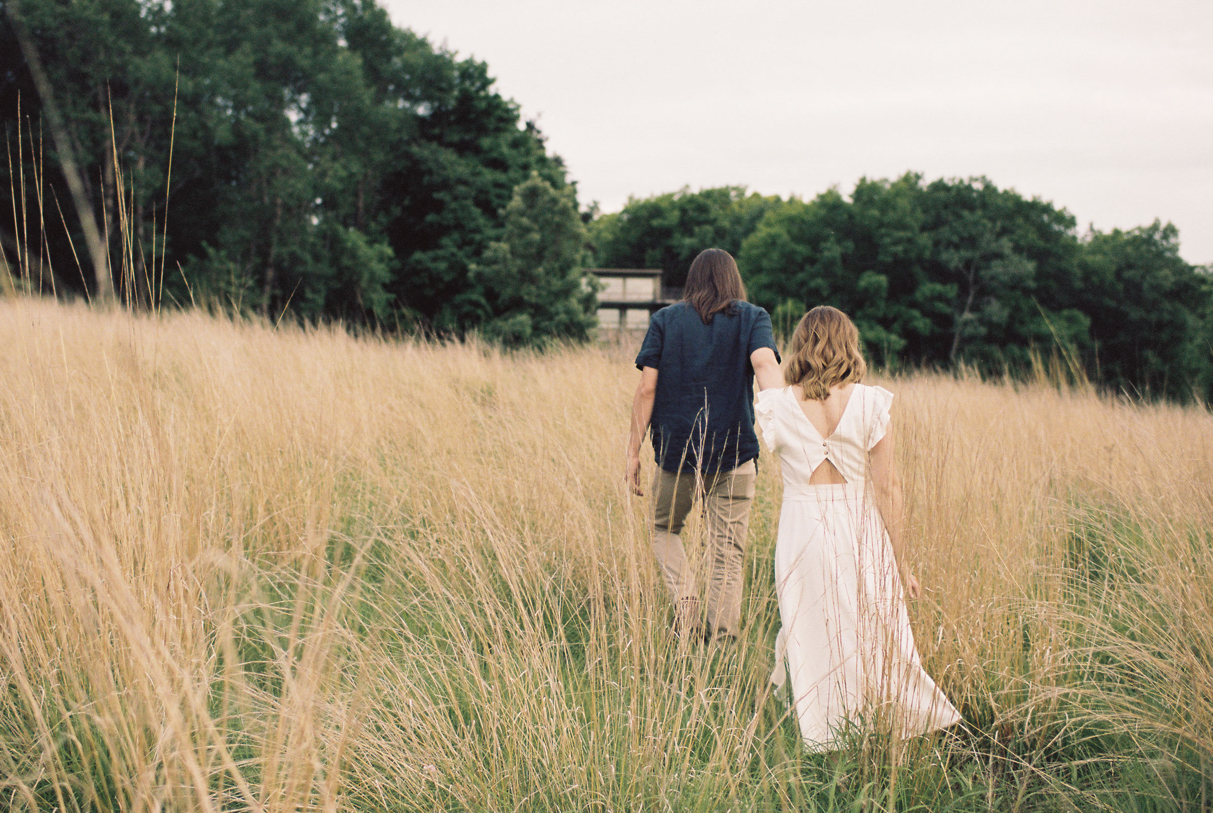 Man leading his fiancé through a field