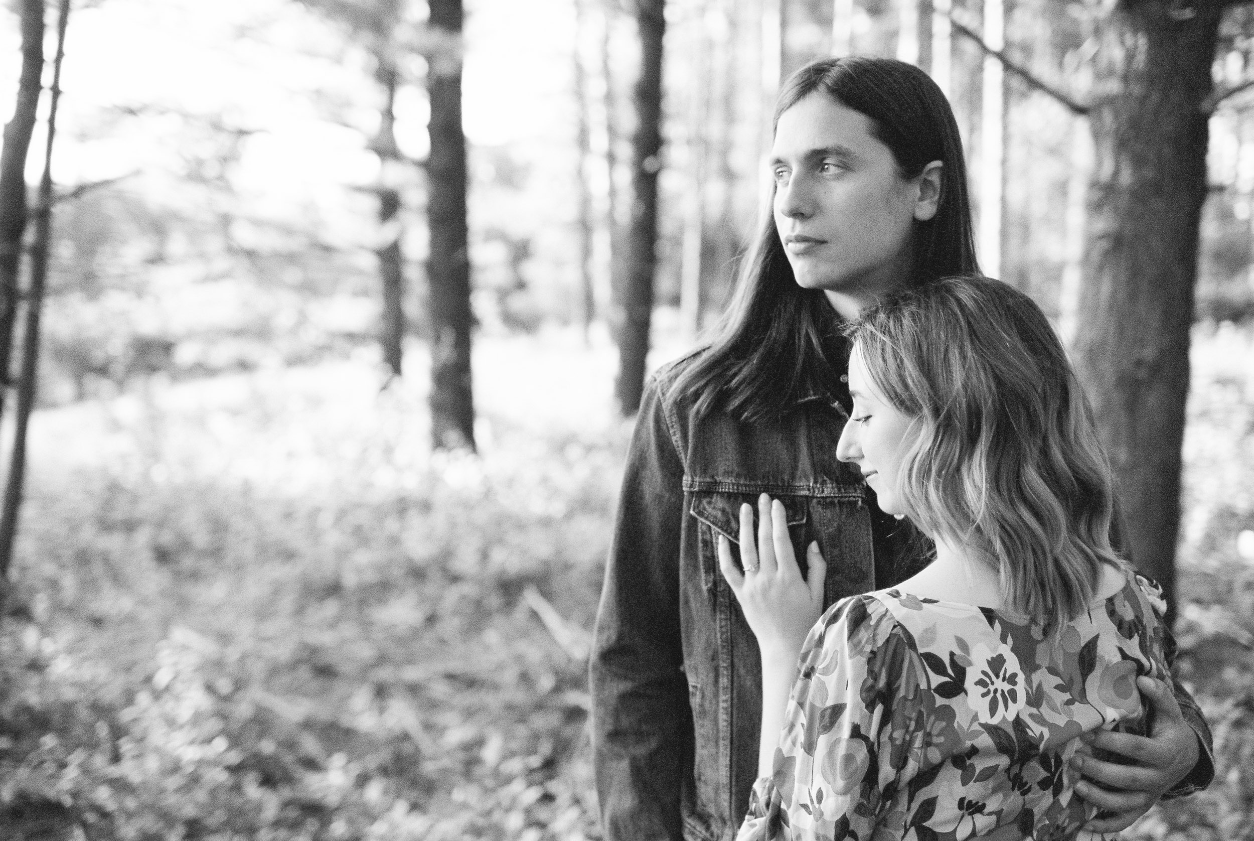 Engaged couple hugging in the woods